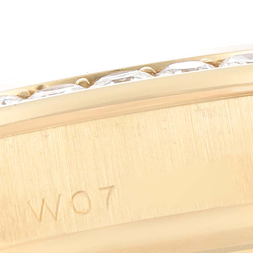 This close-up image shows the side view of the bezel and case of a Rolex Pearlmaster 69298 Women's Yellow Gold Champagne Dial 69298 Women's Yellow Gold Champagne Dial watch, featuring diamonds and part of the engraved model text.