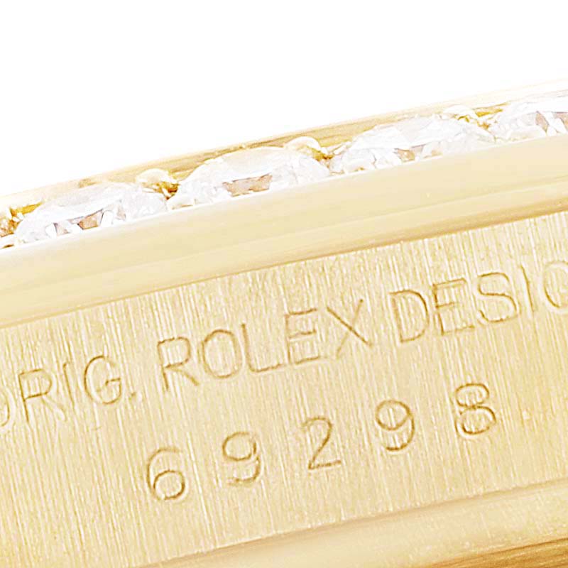 The image shows a close-up of the bezel and engraved case number of a Rolex Pearlmaster 69298 Women's Yellow Gold Champagne Dial 69298 Women's Yellow Gold Champagne Dial watch.