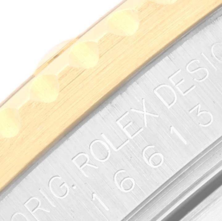 This close-up image shows the bezel and part of the case of a Rolex Submariner 16613 Men's Steel and Gold (two tone) Blue Dial 16613 Men's Steel and Gold (two tone) Blue Dial watch.