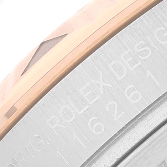 This close-up image shows part of the bezel and engraved text on the case of a Rolex Turn-o-Graph 116261 Men's Steel and Gold (two tone) Silver Dial 116261 Men's Steel and Gold (two tone) Silver Dial watch.