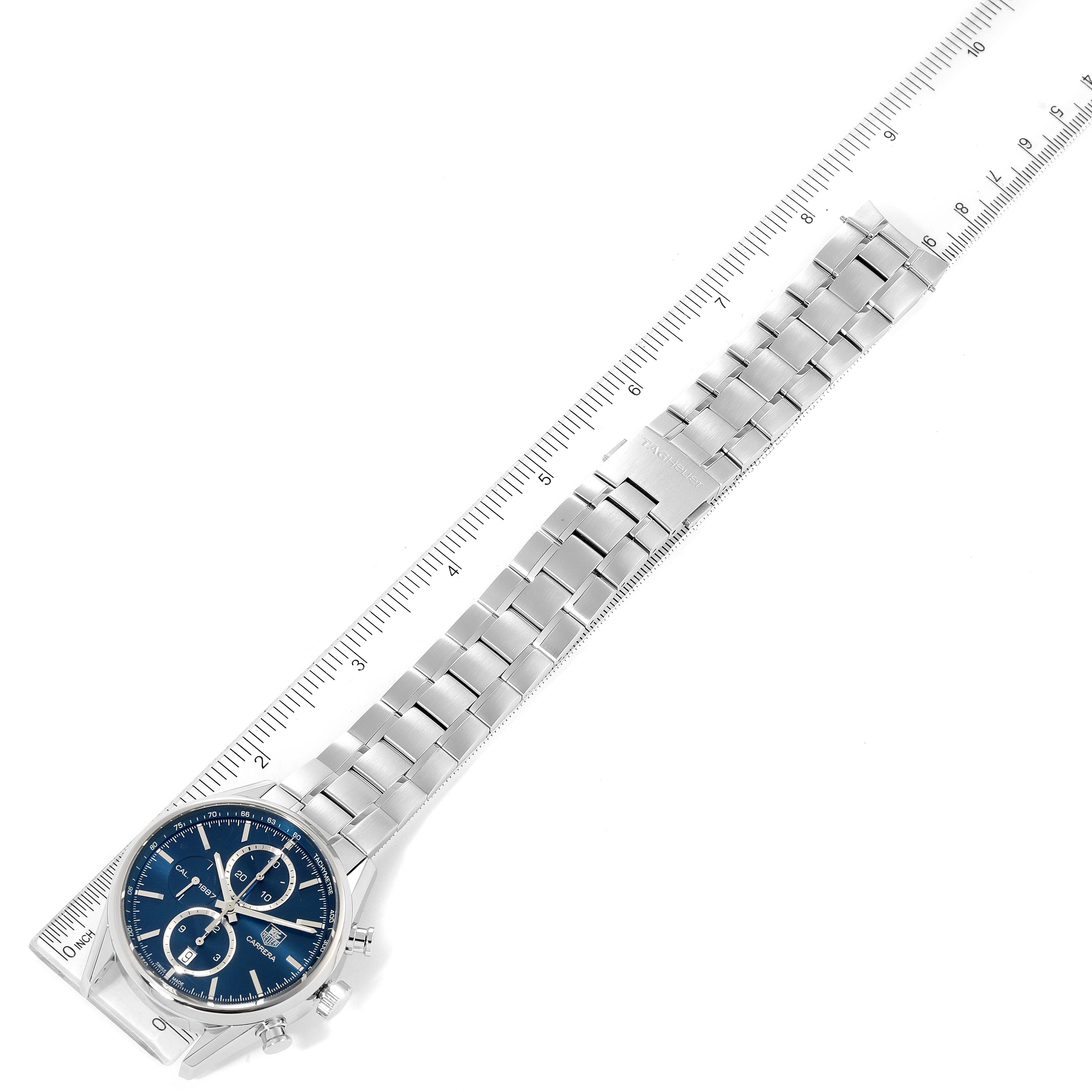 The image shows a top-down view of the Tag Heuer Carrera CAR2115 Men's Stainless Steel Blue Dial CAR2115 Men's Stainless Steel Blue Dial watch displaying its face, bracelet, and part of a ruler.