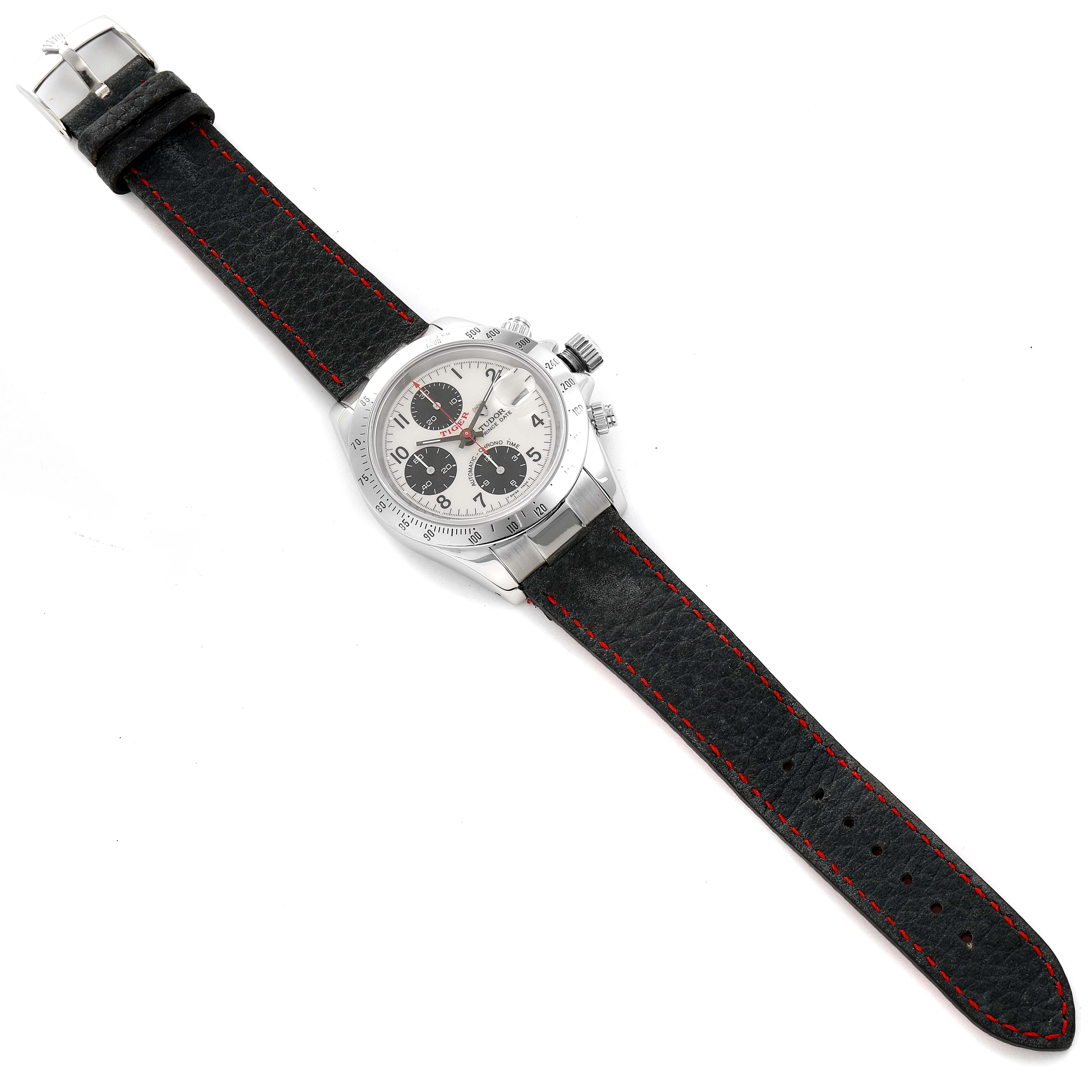 The Tudor Prince model watch is shown from a top-down angle with a black leather strap featuring red stitching.