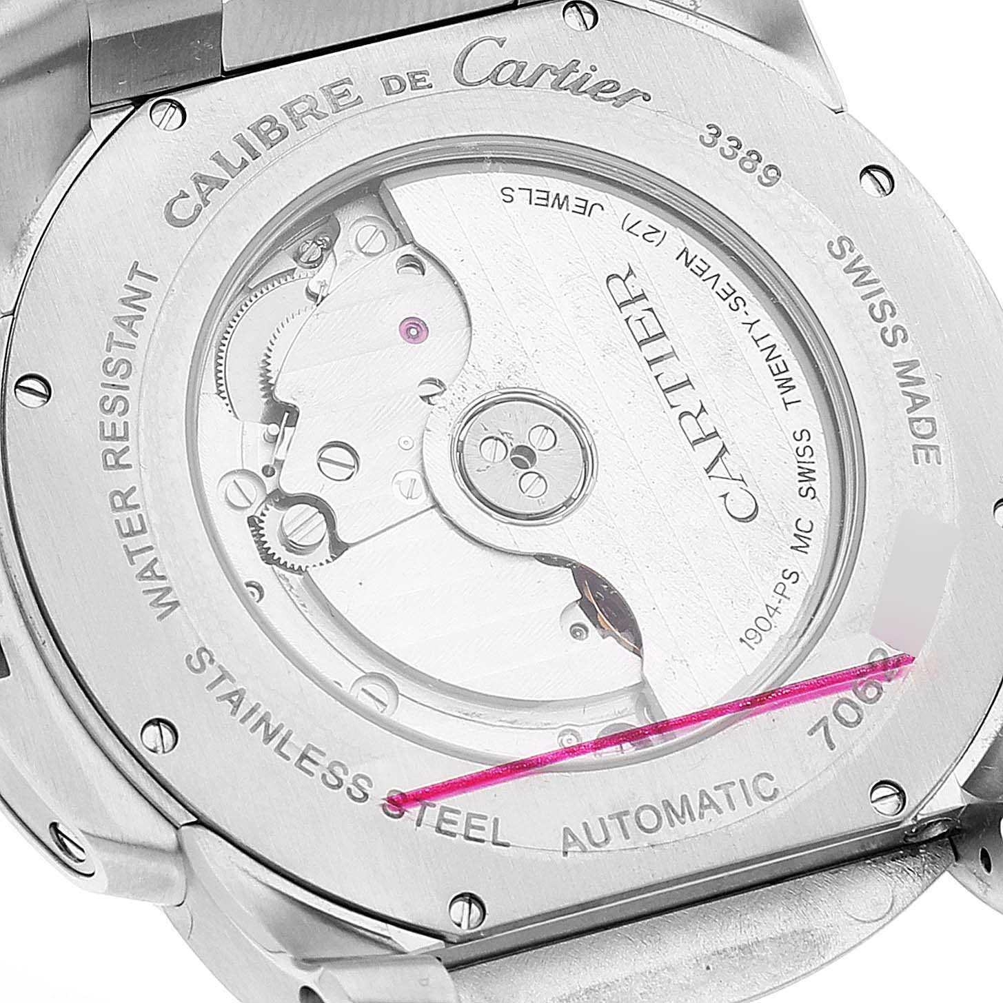 The image shows the case back of the Calibre de Cartier model by Cartier, highlighting its automatic movement and stainless steel construction.