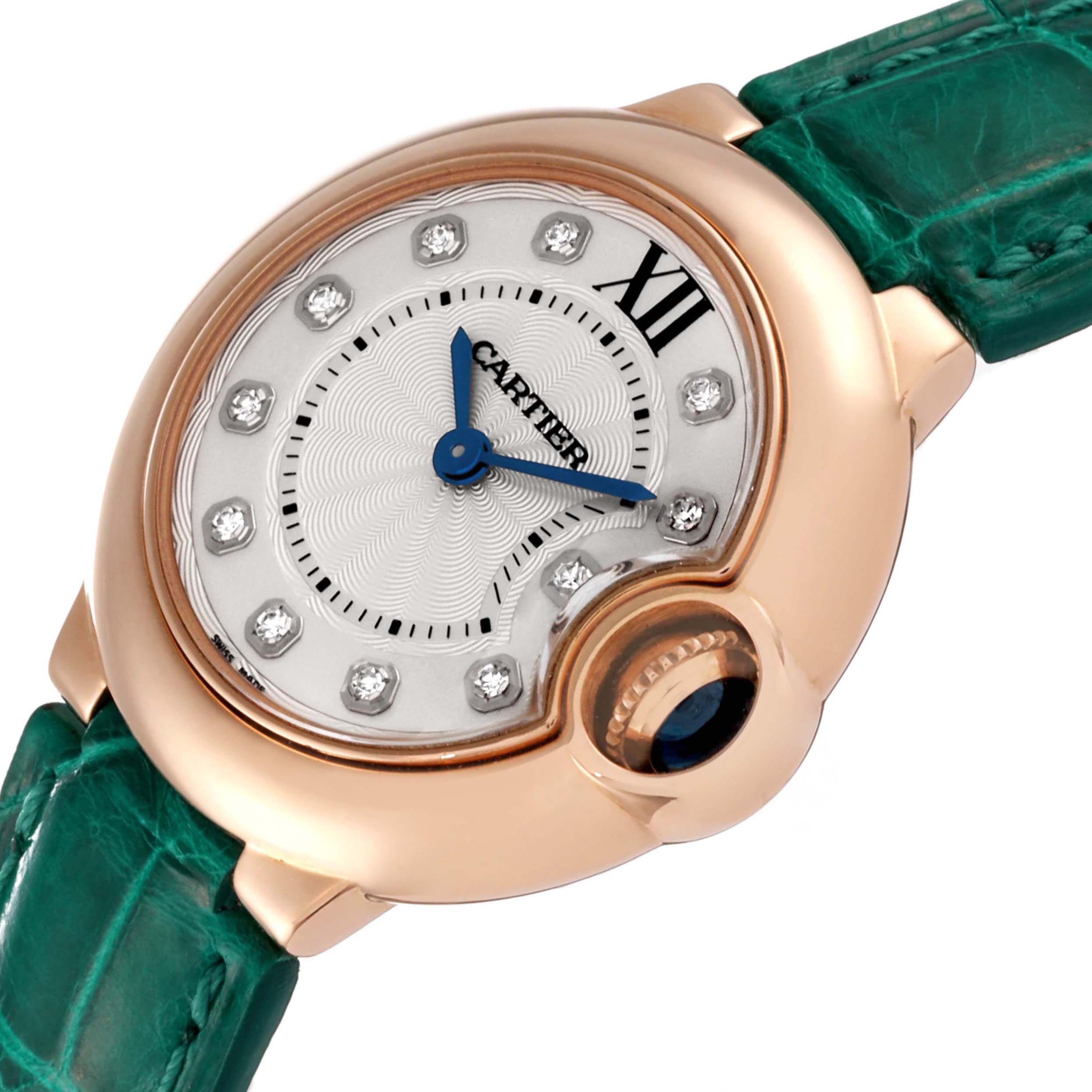 The image shows a close-up of the Cartier Ballon Bleu WE902050 Women's Rose Gold Silver Dial WE902050 Women's Rose Gold Silver Dial watch face and part of its green strap, highlighting its distinctive crown and design.