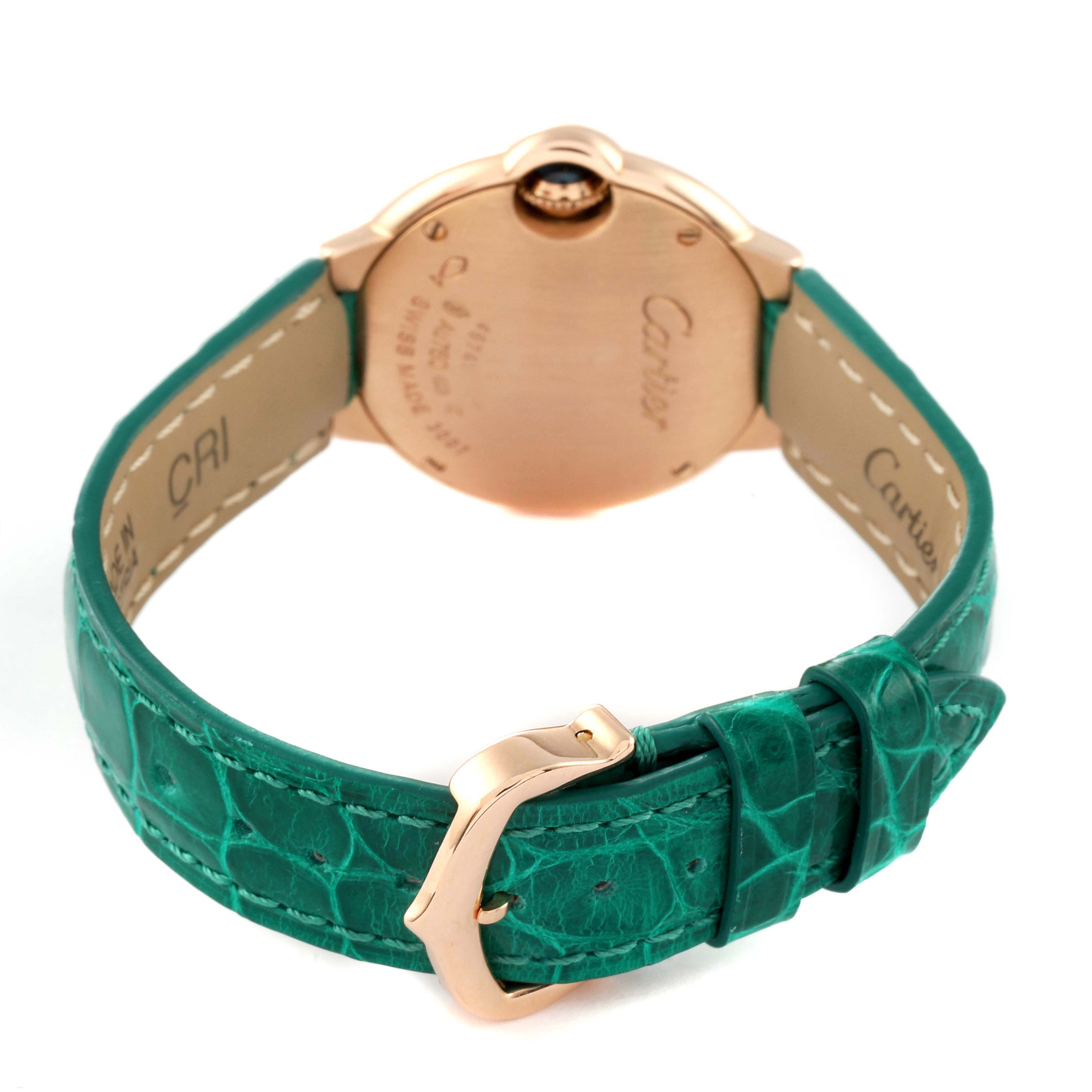 This image shows the back of the Cartier Ballon Bleu WE902050 Women's Rose Gold Silver Dial WE902050 Women's Rose Gold Silver Dial watch and its green leather strap.