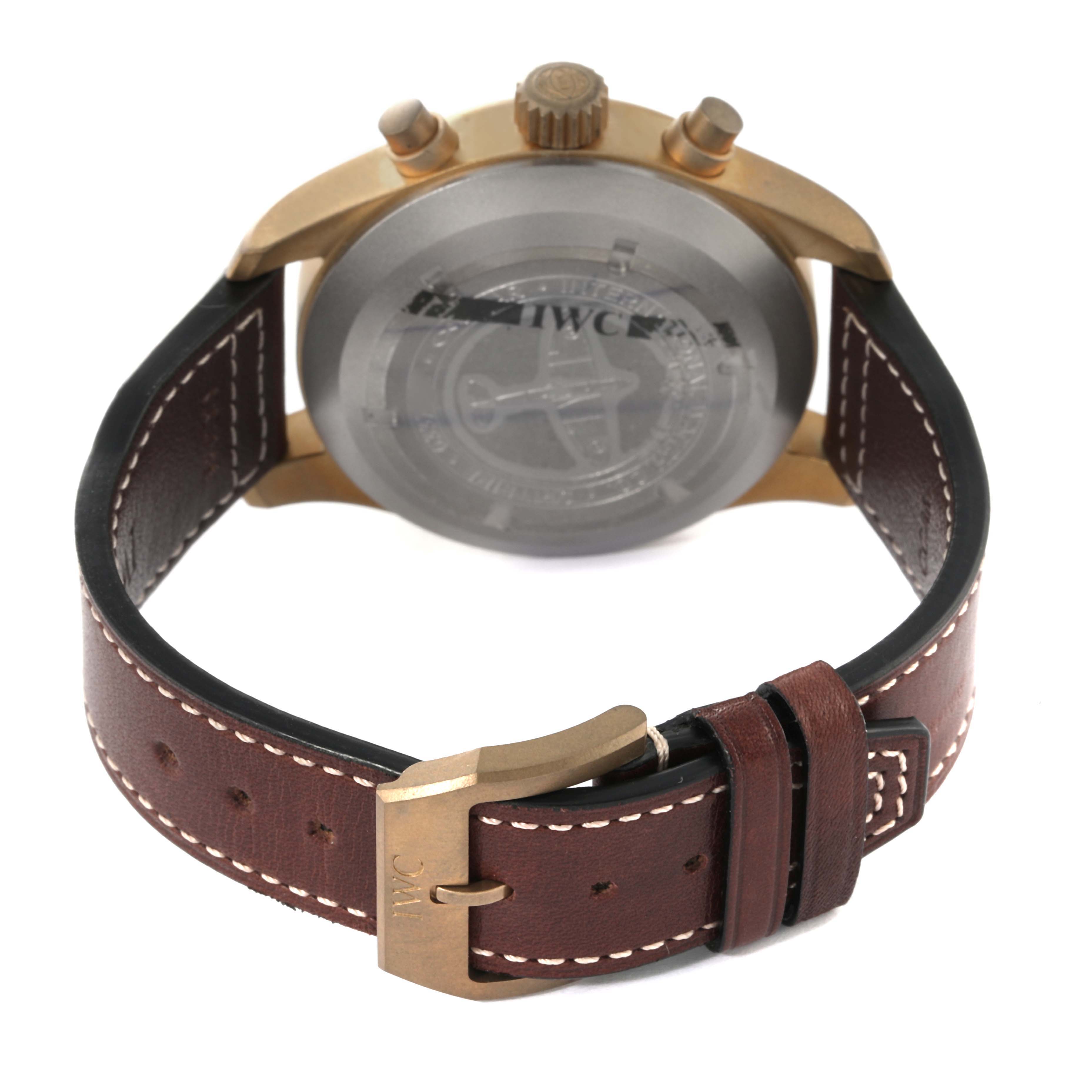 The image shows the back view of the IWC Pilot IW387902 Men's Bronze Green Dial IW387902 Men's Bronze Green Dial model watch, with its leather strap and buckle prominently displayed.