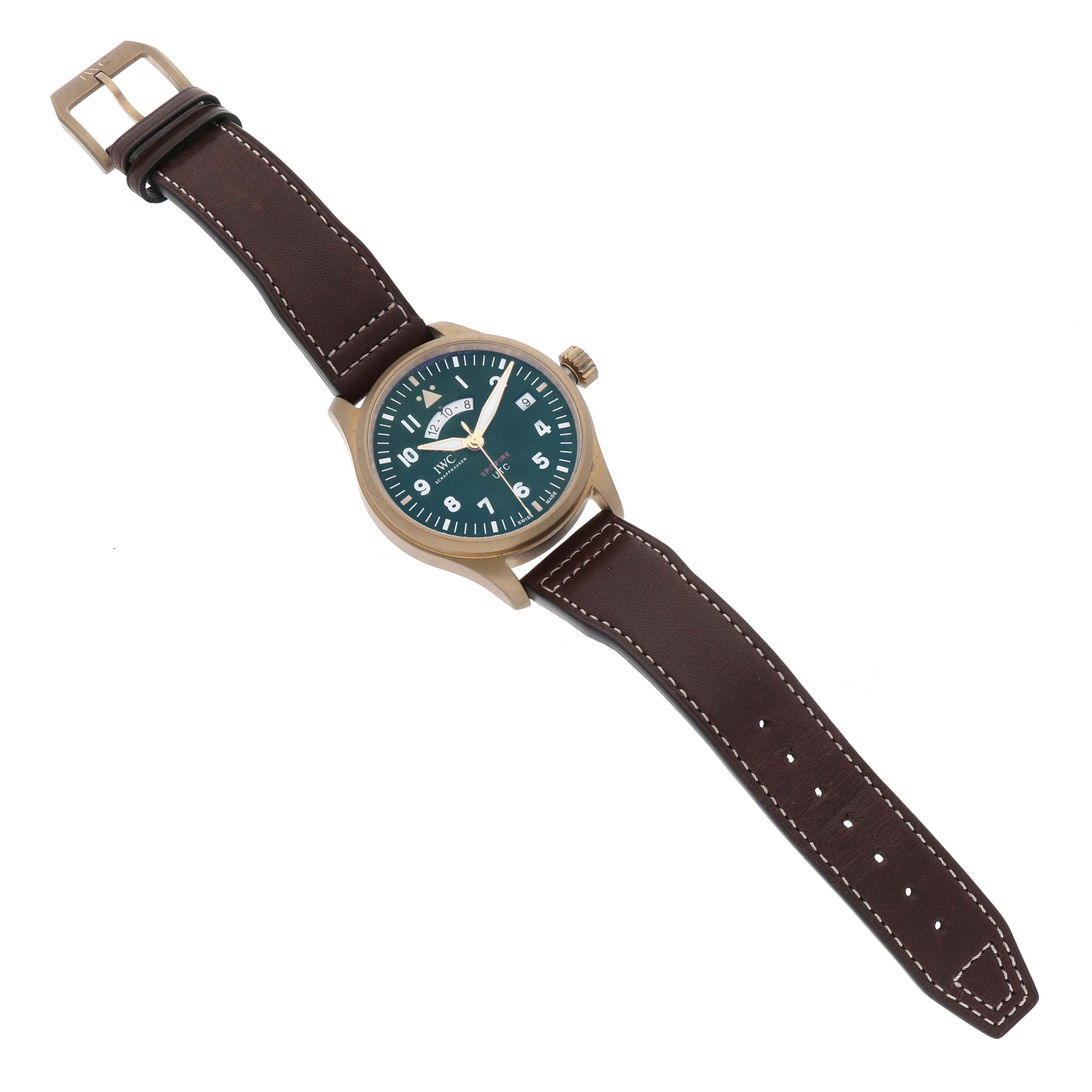 The IWC Pilot IW327101 Men's Bronze Green Dial IW327101 Men's Bronze Green Dial watch is shown from a top-down angle with its face, dial, crown, and brown leather strap visible.