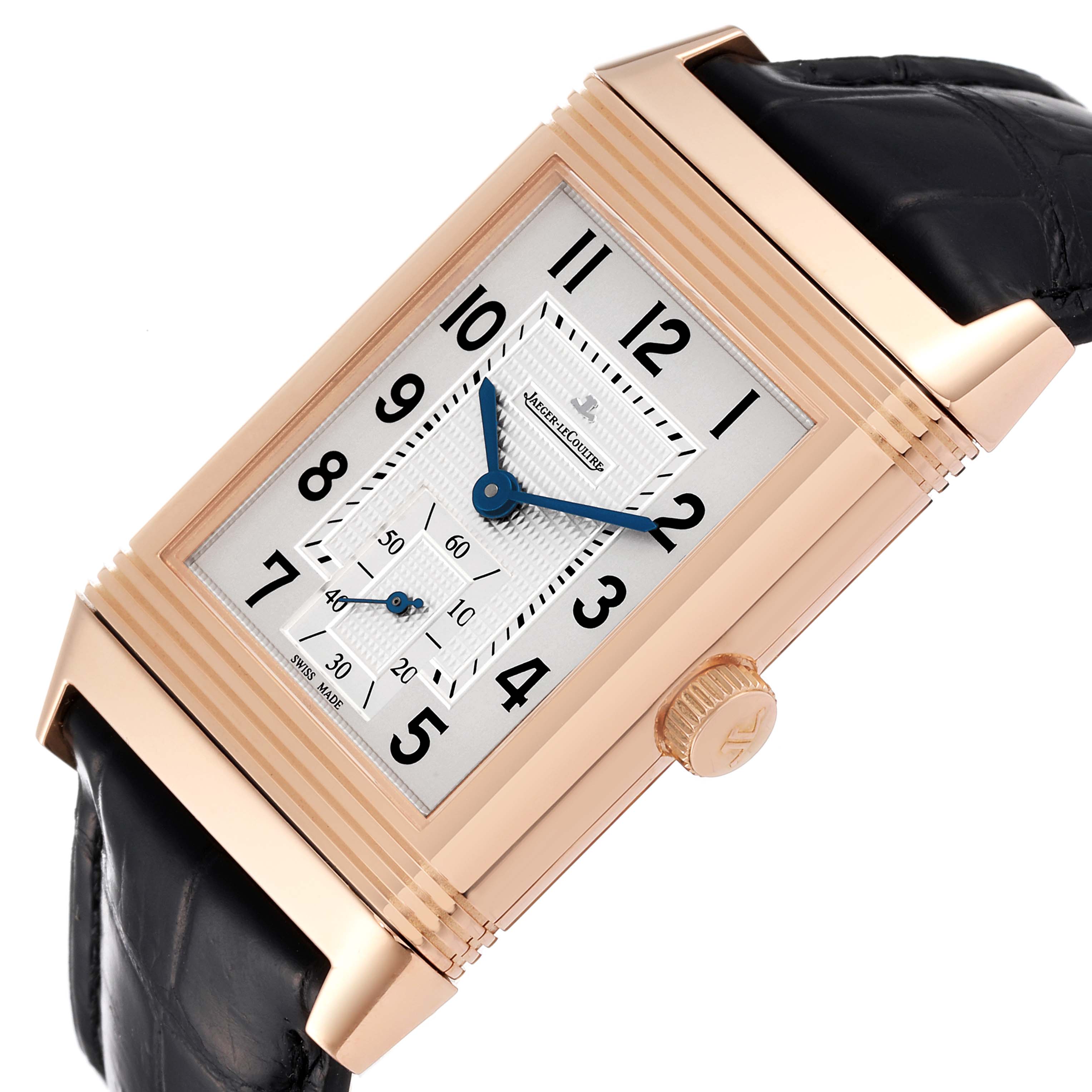 The Jaeger-LeCoultre Reverso watch is shown at an angle, highlighting its rectangular face, crown, and part of the leather strap.