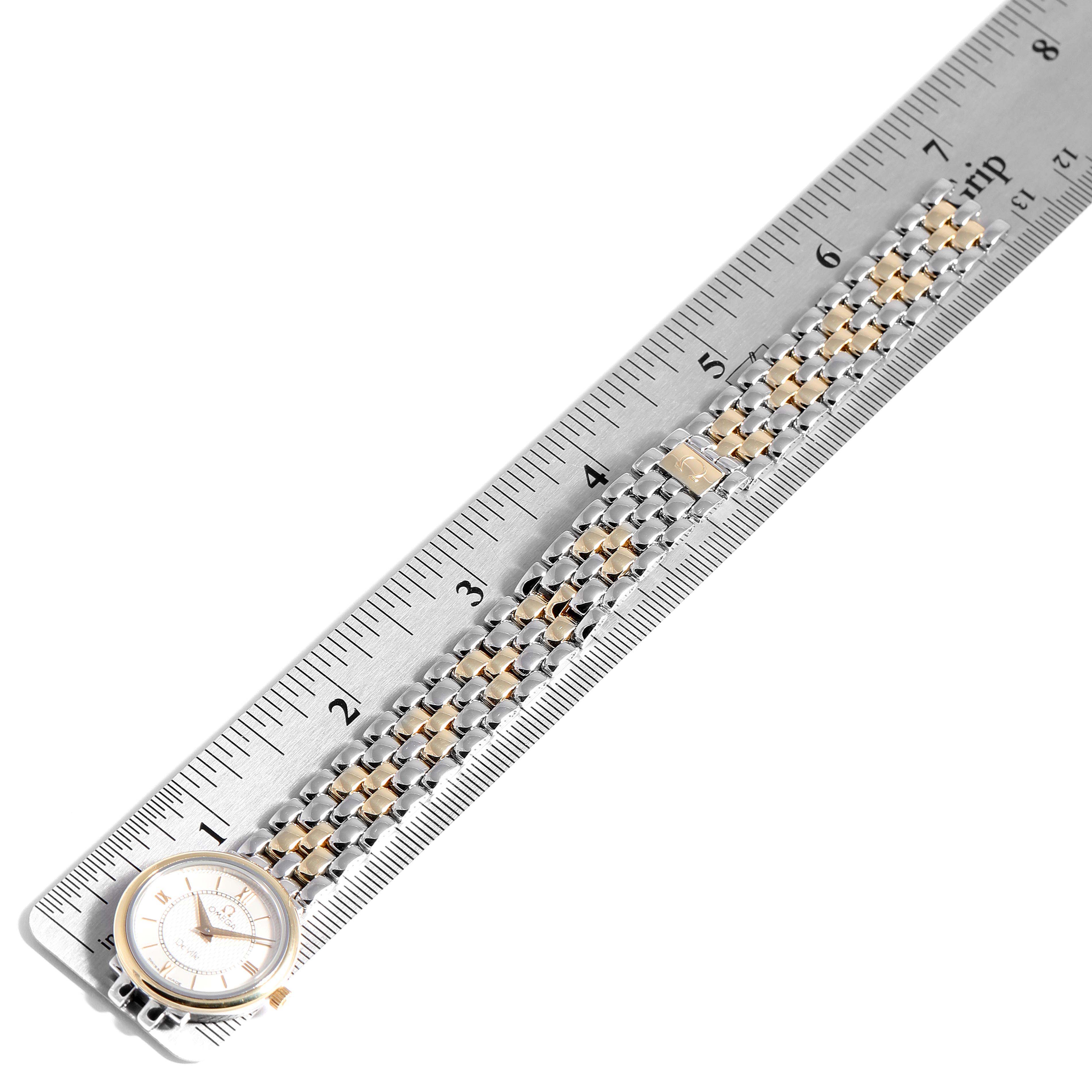 The image shows a top view of the Omega 7374.31.00 Women's Steel and Gold (two tone) Silver Dial 7374.31.00 Women's Steel and Gold (two tone) Silver Dial DeVille Classic Steel Yellow Gold Ladies Watch 7374.31.00 laid next to a ruler.