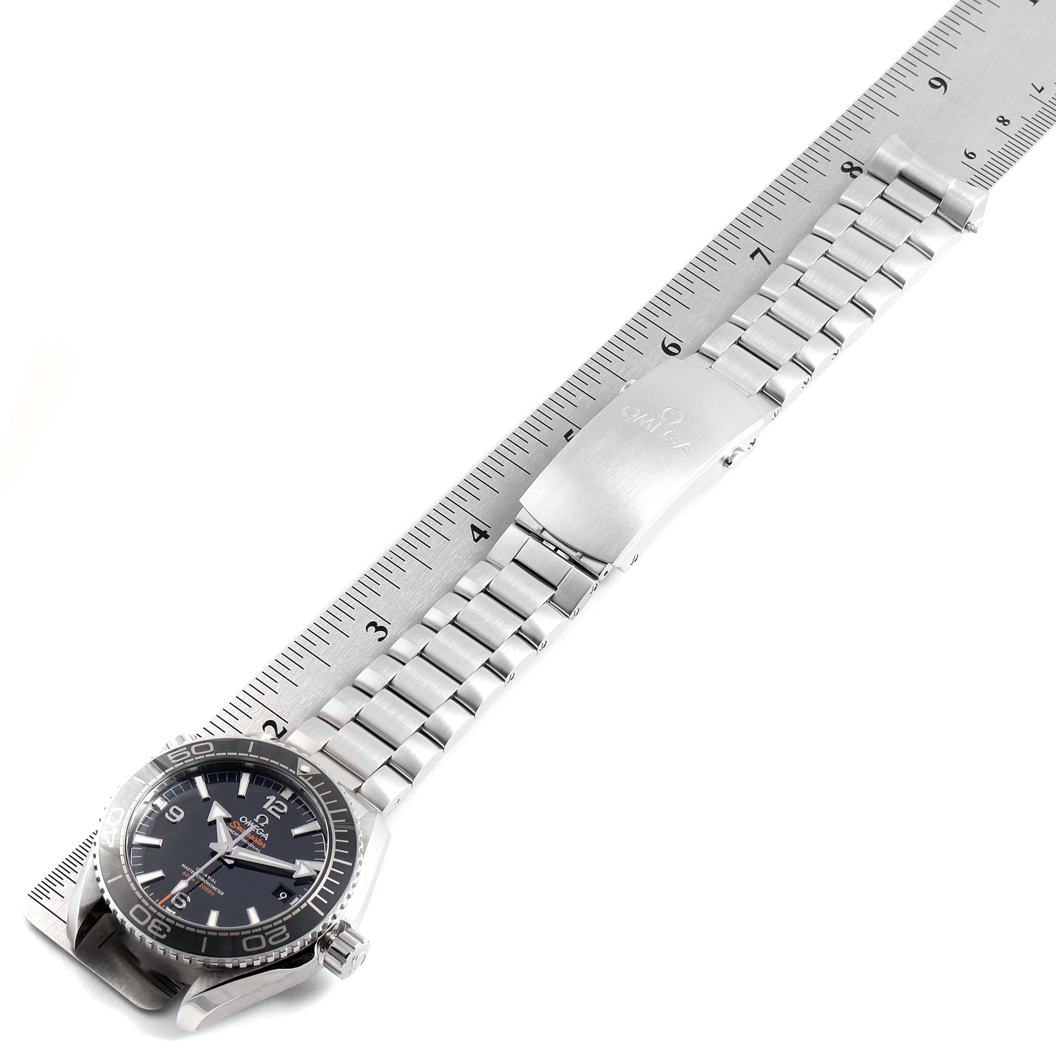 The Omega Planet Ocean 215.30.44.21.01.001 Men's Stainless Steel Black Dial 215.30.44.21.01.001 Men's Stainless Steel Black Dial watch is shown from a top-down angle alongside a ruler for size comparison.