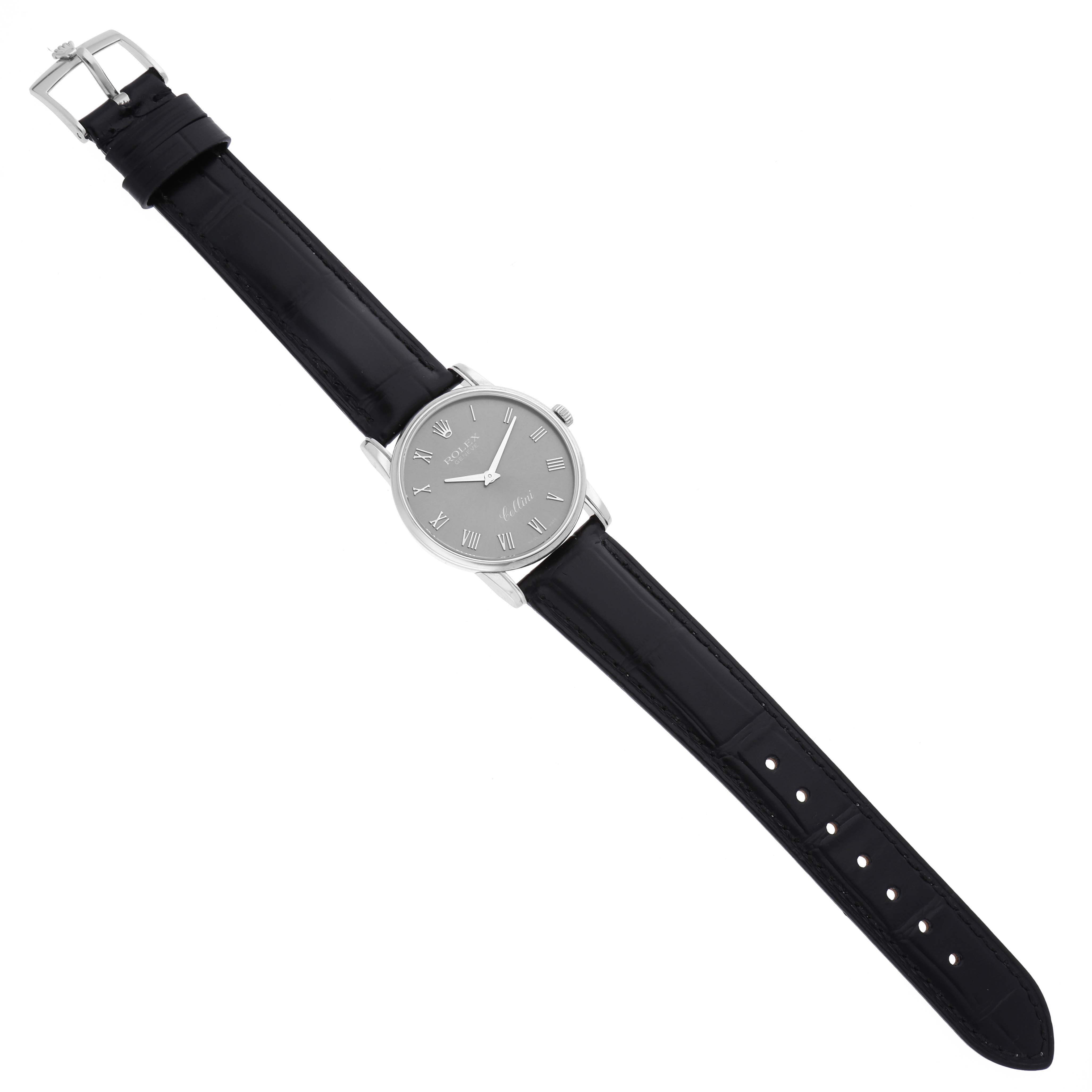 The image shows a Cellini model by Rolex at a top-down angle, displaying the watch face, black leather strap, and buckle.