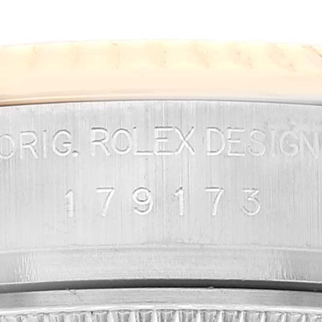Close-up of the side of a Rolex Datejust 179173 Women's Steel and Gold (two tone) Silver Dial 179173 Women's Steel and Gold (two tone) Silver Dial watch, showing the engraved model number and "ORIG. ROLEX DESIGN."