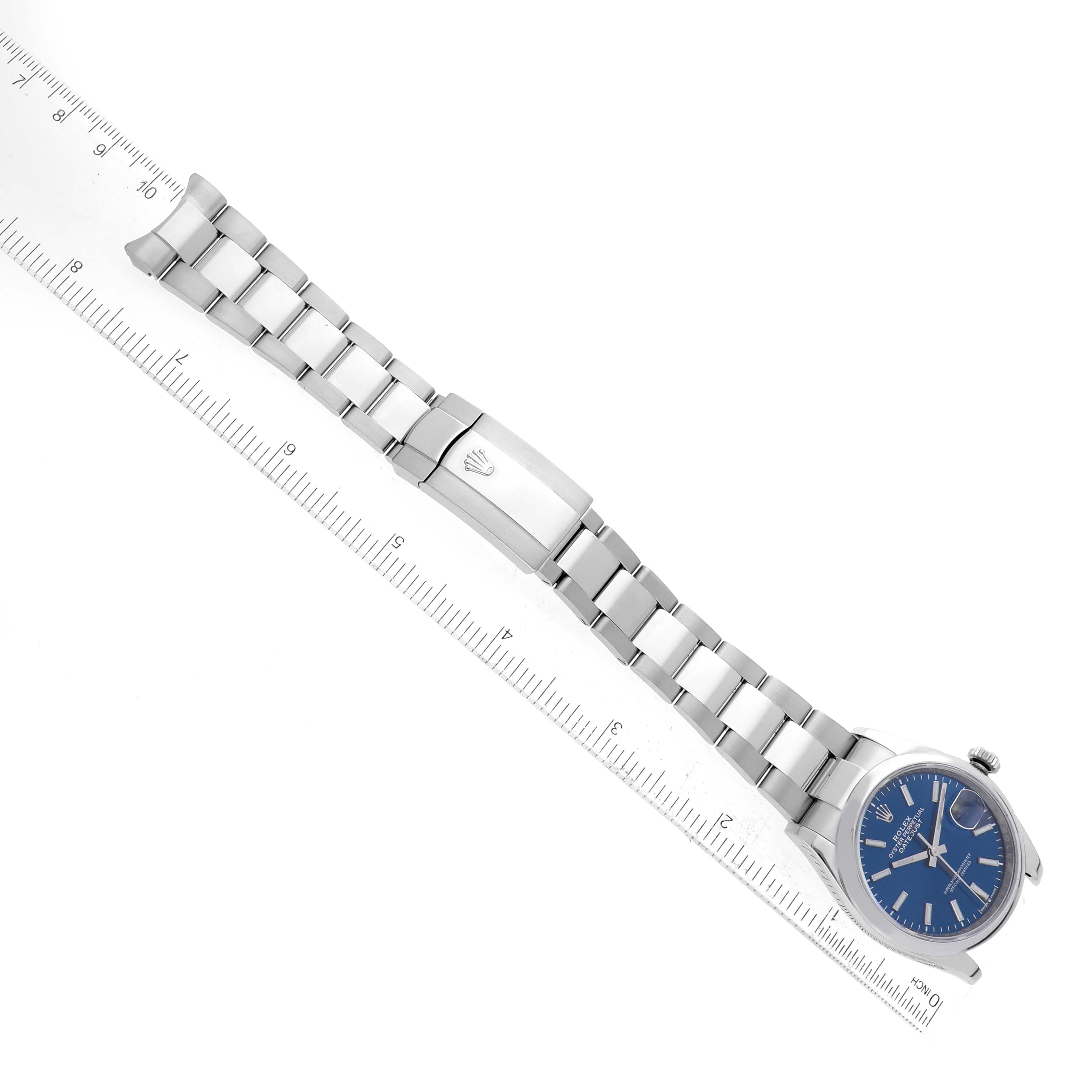 The Rolex Datejust 126200 Men
s Stainless Steel Blue Dial 126200 Men
s Stainless Steel Blue Dial watch is shown at a diagonal angle, featuring the bracelet, clasp, and blue dial.