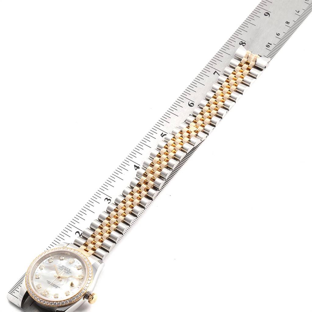 The image shows a Rolex Datejust 116243 Men's Steel and Gold (two tone) Mother of Pearl Dial 116243 Men's Steel and Gold (two tone) Mother of Pearl Dial watch with a metal and gold bracelet measured against a ruler.