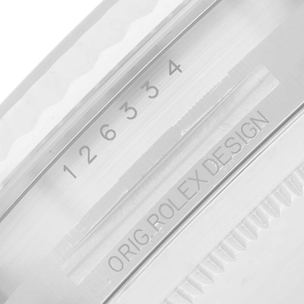 The image shows the case side and bezel of a Rolex Datejust 41 126334 Men
s Stainless Steel Silver Dial, highlighting engravings with numbers and "ORIG ROLEX DESIGN."