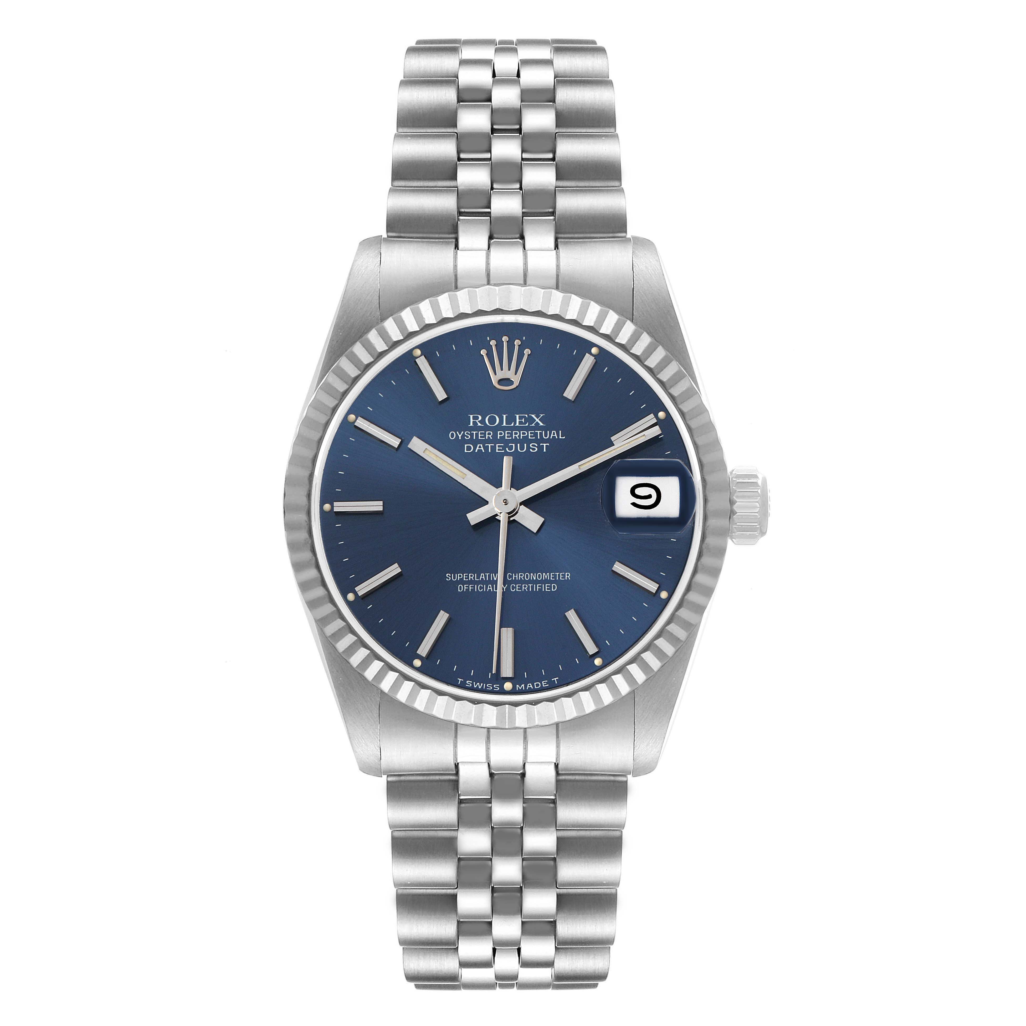 The Rolex Datejust mid-size model is shown from a frontal angle, highlighting its blue dial, silver indices, and bracelet.