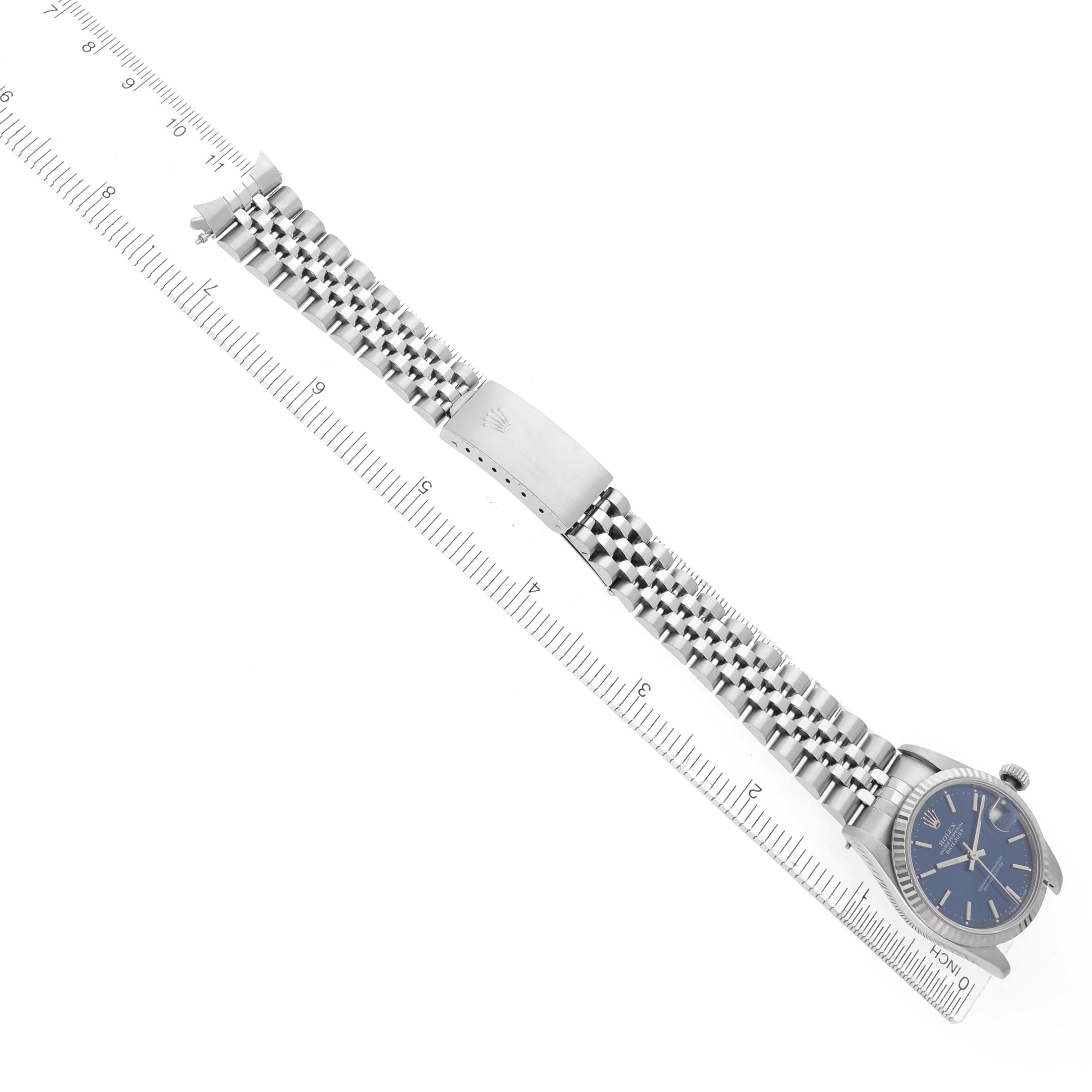 The Rolex Mid-Size 68274 Women's Stainless Steel Blue Dial watch is shown from a top view, featuring the face, entire bracelet, and clasp, aligned with a ruler.