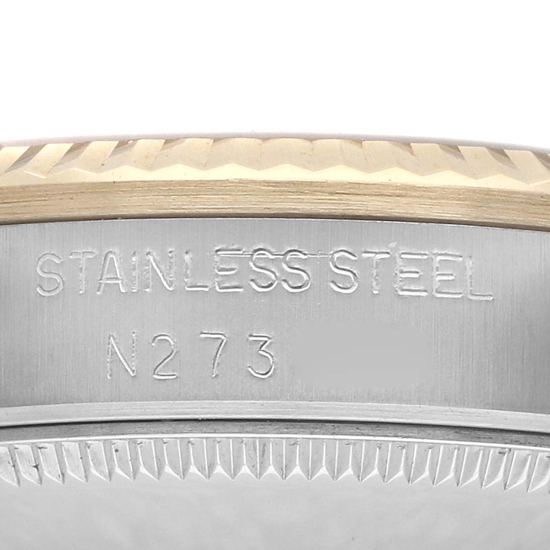The image shows a close-up of the edge of a Rolex Mid-Size 68273 Women
s Steel and Gold (two tone) Champagne Dial model watch, highlighting the stainless steel case and part of the bezel.