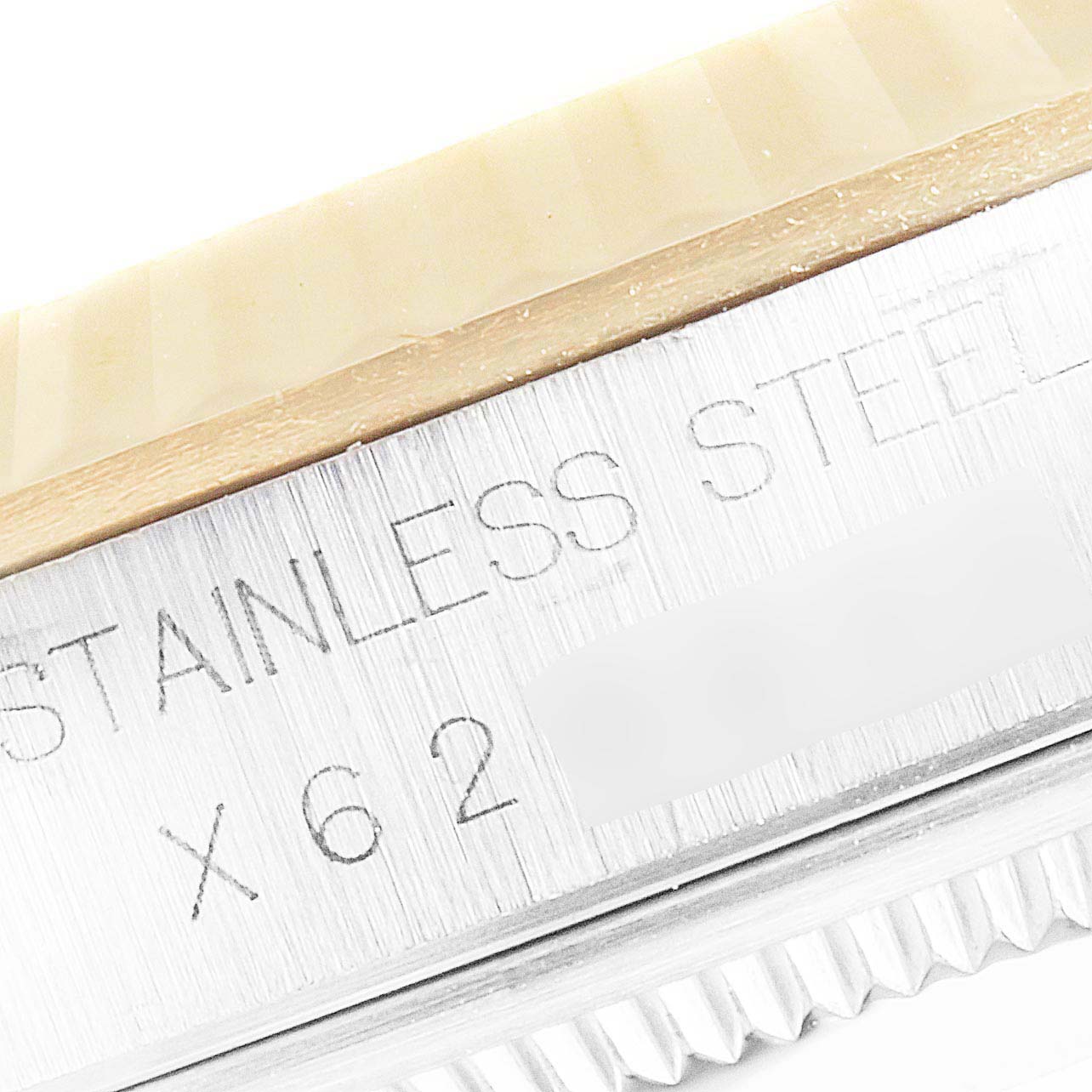 This close-up image of a Rolex Datejust 16233 Men's Steel and Gold (two tone) Champagne Dial 16233 Men's Steel and Gold (two tone) Champagne Dial showcases the bezel and part of the engraved stainless steel casing.