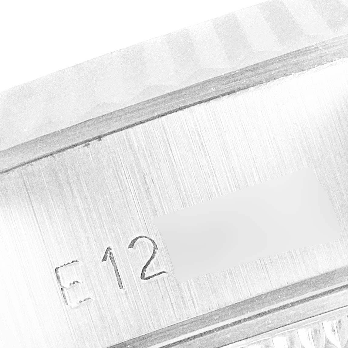 This image shows a close-up of the side engraving and fluted bezel of a Rolex Datejust 69174 Women's Stainless Steel Silver Dial 69174 Women's Stainless Steel Silver Dial watch.