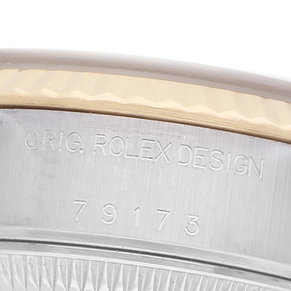The image shows a close-up of the side of a Rolex Datejust 79173 Women's Steel and Gold (two tone) Champagne Dial, focusing on the engraved model number and design label.