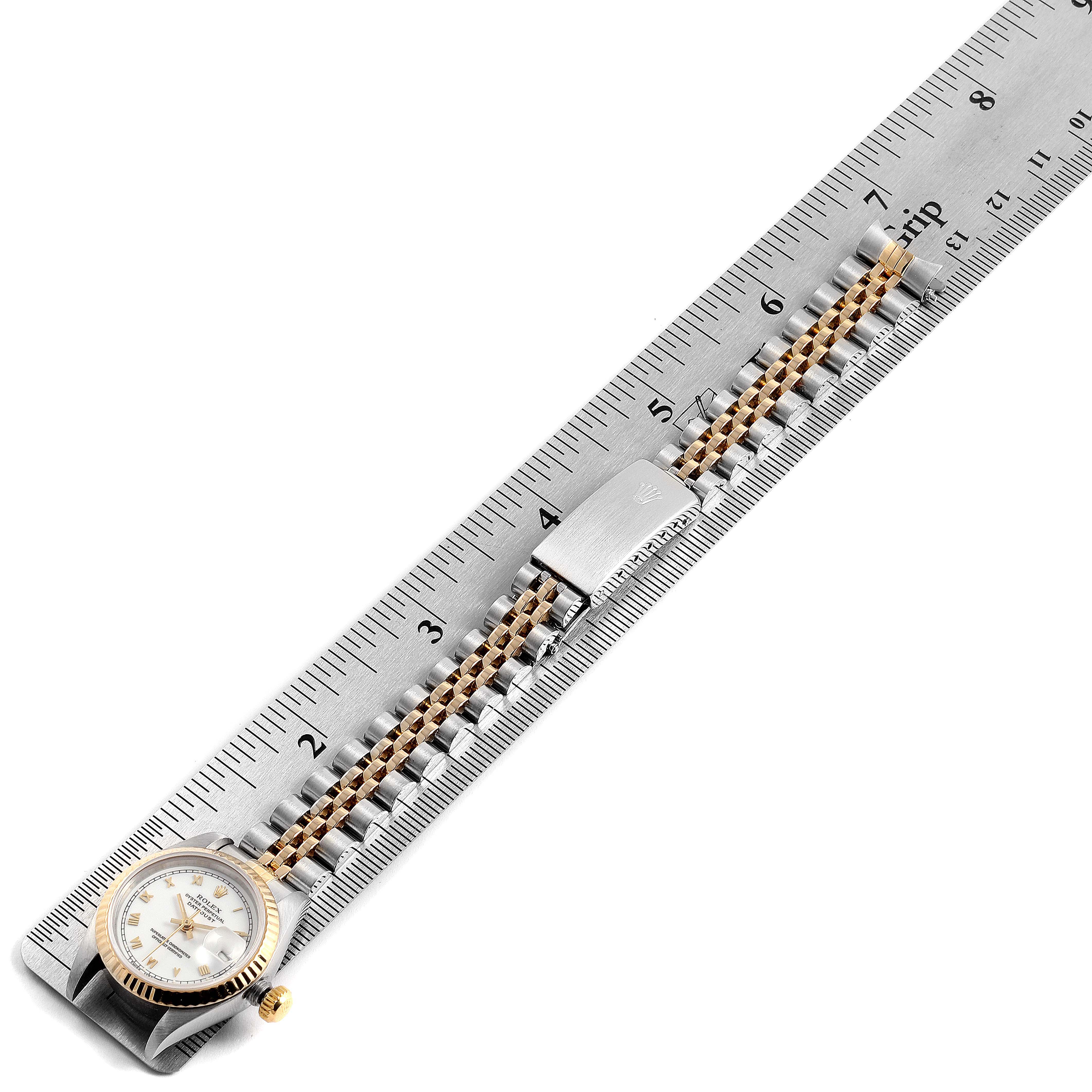 The image shows a Rolex Datejust 69173 Women's Steel and Gold (two tone) White Dial 69173 Women's Steel and Gold (two tone) White Dial watch laid flat against a ruler, highlighting its bracelet and clasp.