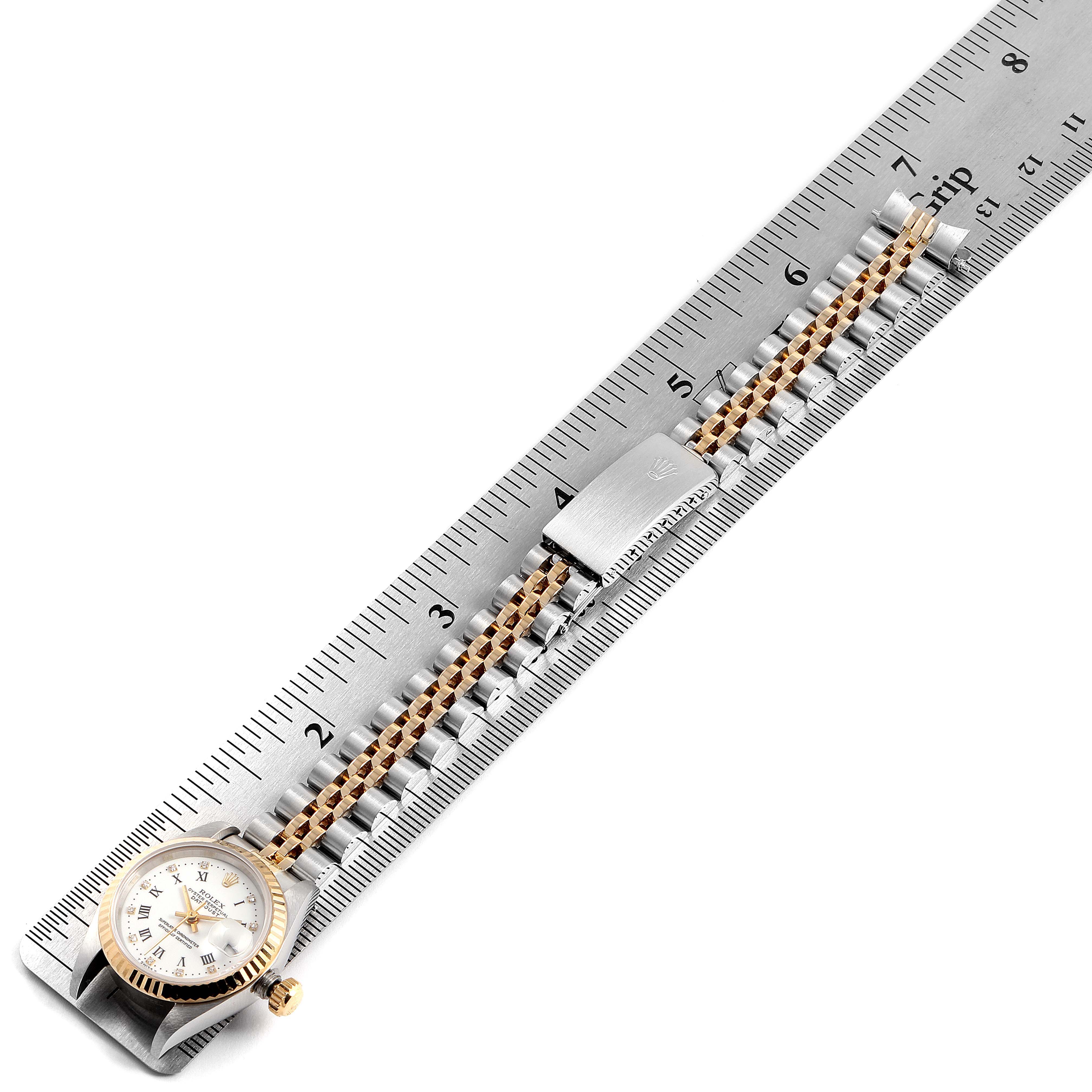 This image shows a Rolex Datejust 69173 Women's Steel and Gold (two tone) White Dial 69173 Women's Steel and Gold (two tone) White Dial watch placed in a ruler, displaying the face, bezel, and bracelet with clasp.