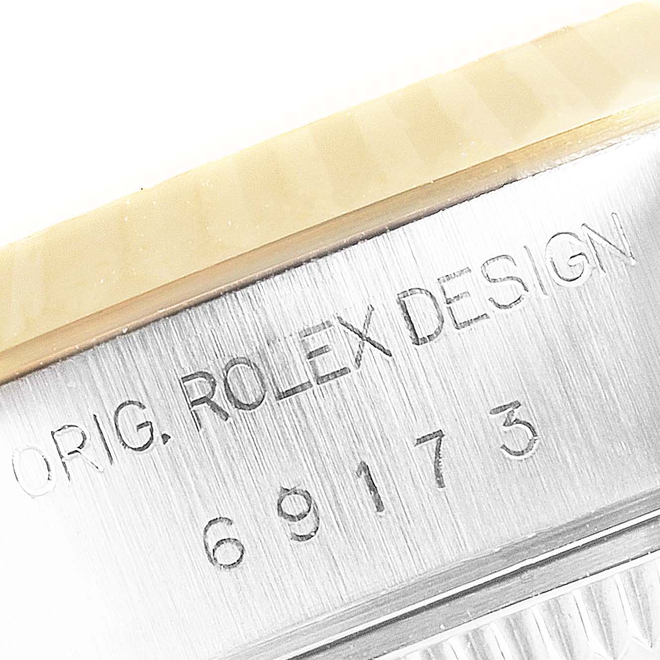 The image shows a close-up of the side engraved with "ORIG. ROLEX DESIGN" and model number of the Rolex Datejust 69173 Women's Steel and Gold (two tone) White Dial 69173 Women's Steel and Gold (two tone) White Dial.