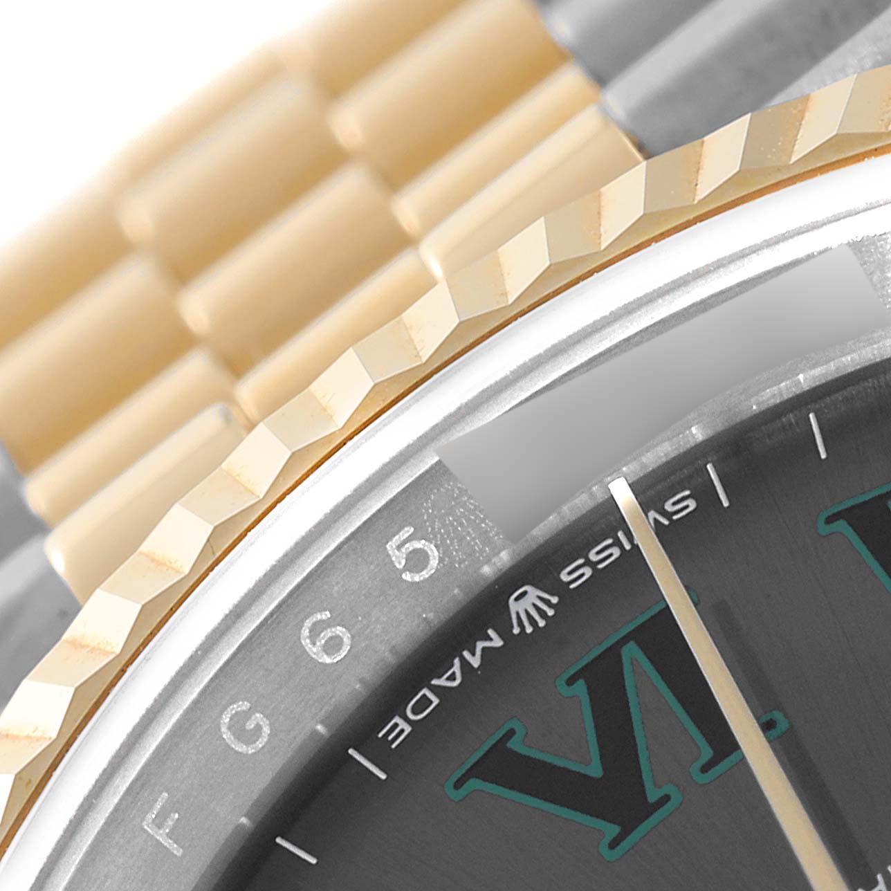 This close-up image of the Rolex Datejust 126233 Men's Steel and Gold (two tone) Grey Dial 126233 Men's Steel and Gold (two tone) Grey Dial shows the fluted bezel, part of the dial with Roman numerals, "Swiss Made" text, and part of the bracelet.