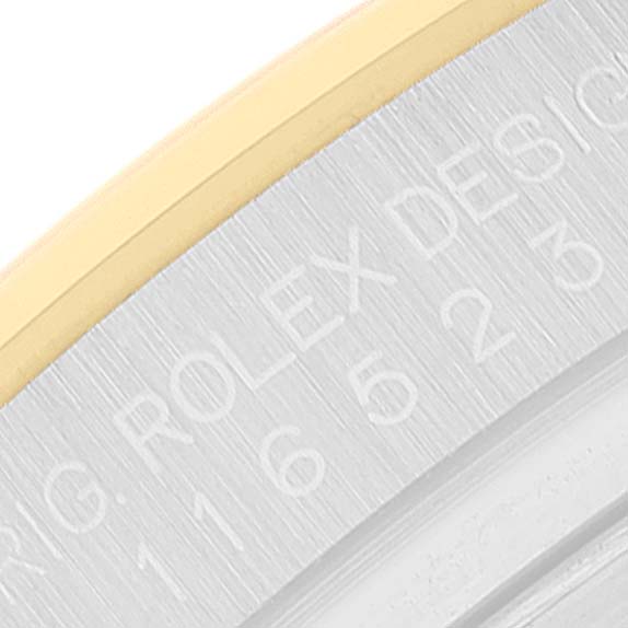 The image shows a close-up of the engraved side of a Rolex Daytona 116523 Men's Steel and Gold (two tone) Black Dial 116523 Men's Steel and Gold (two tone) Black Dial watch case.