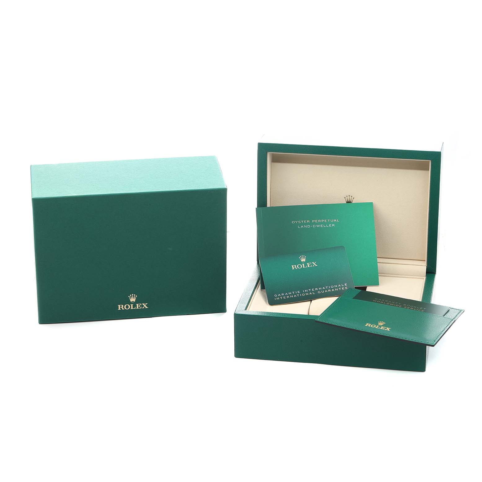 The image shows the packaging and booklets for the Rolex Land-Dweller model, including a box and guarantee cards.