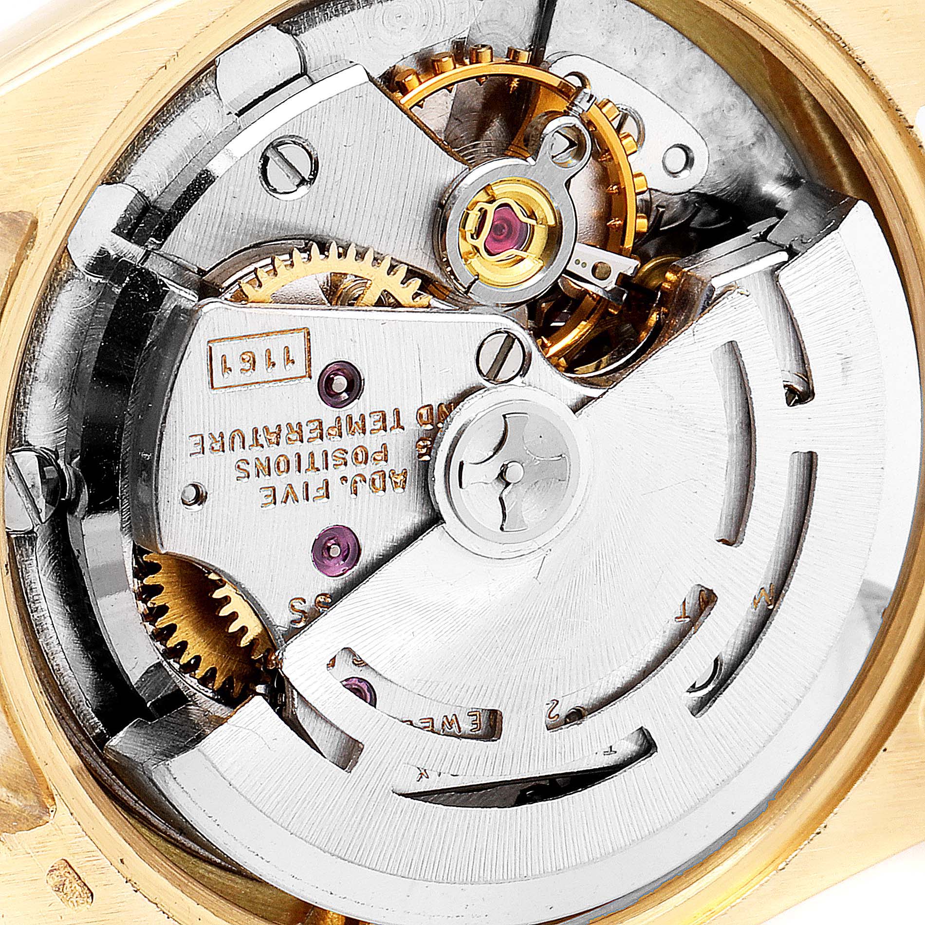 The image shows the internal mechanism of a Rolex Oyster Perpetual 6615 Women
s Yellow Gold Silver Dial 6615 Women
s Yellow Gold Silver Dial watch viewed from the back, highlighting gears and components.