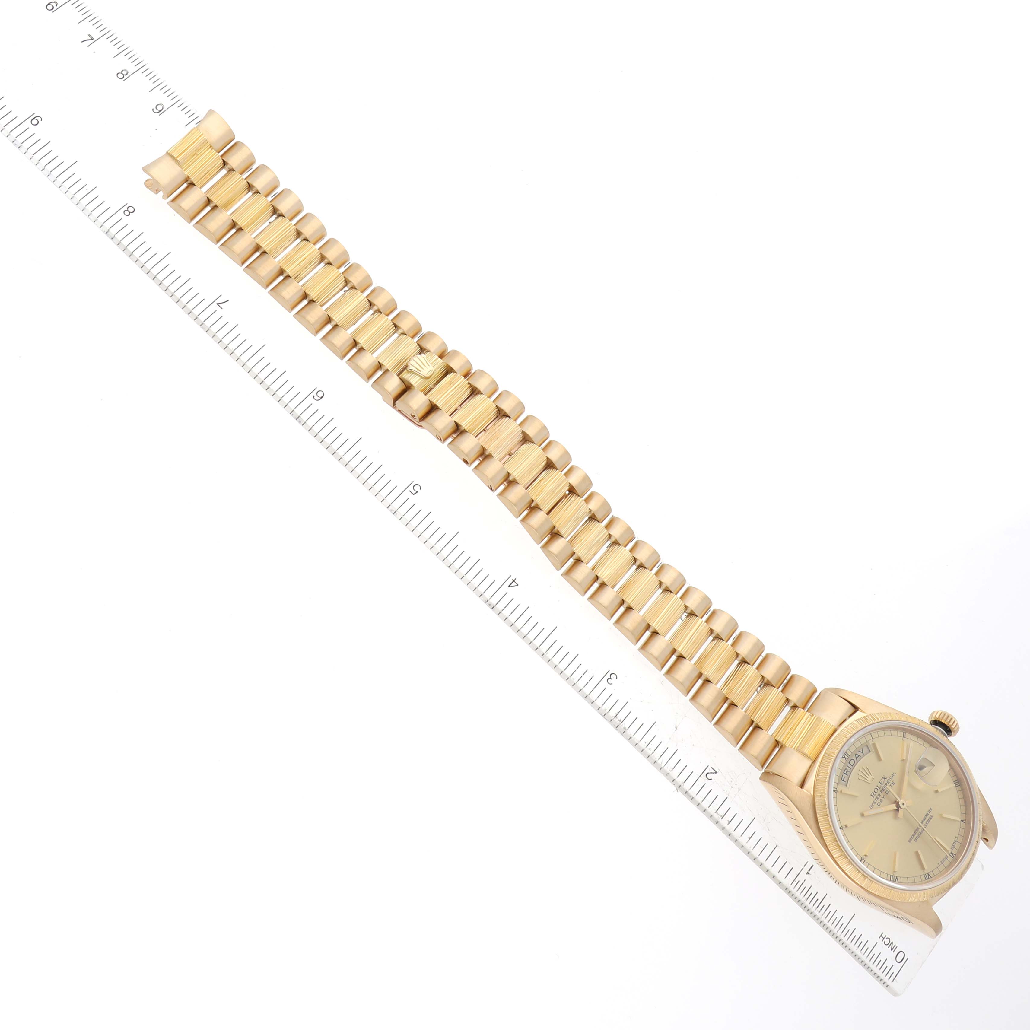 The image shows a Rolex President 18078 Men
s Yellow Gold Champagne Dial 18078 Men
s Yellow Gold Champagne Dial model watch laid flat with its gold bracelet aligned along a ruler for measurement.