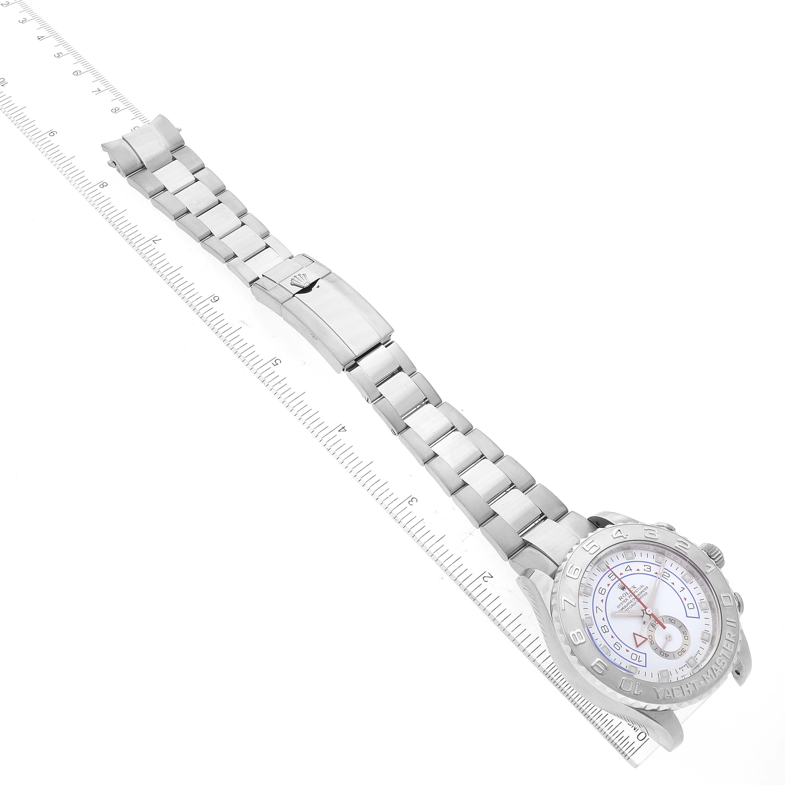 The image shows a top-down view of a Rolex Yacht-Master 116689 Men's White Gold White Dial 116689 Men's White Gold White Dial watch with the full bracelet and clasp visible, alongside a ruler for scale.