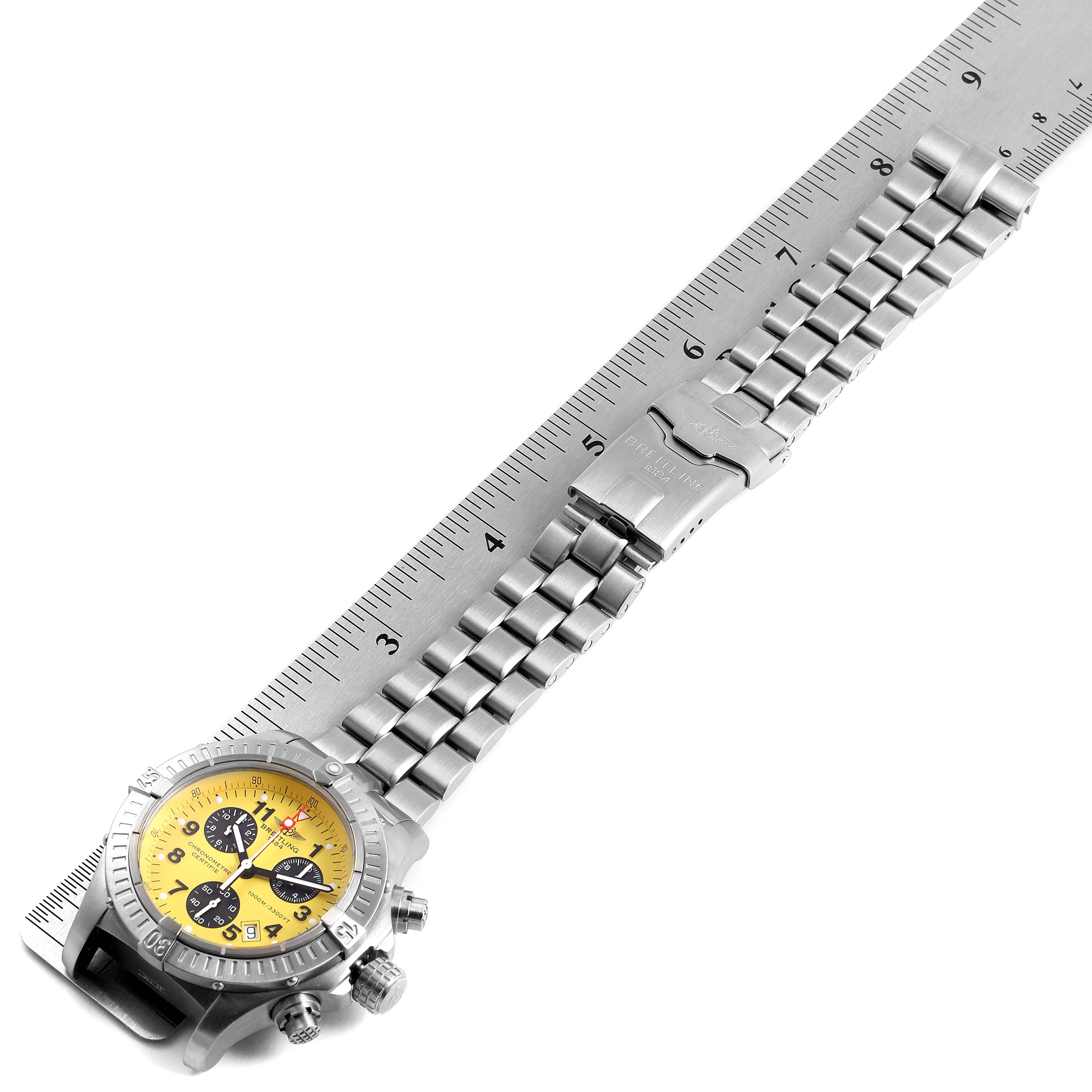 The image shows a Breitling Avenger E73360 Men's Titanium Yellow Dial E73360 Men's Titanium Yellow Dial watch, featuring its face, bezel, crown, chronograph pushers, and full metal bracelet.