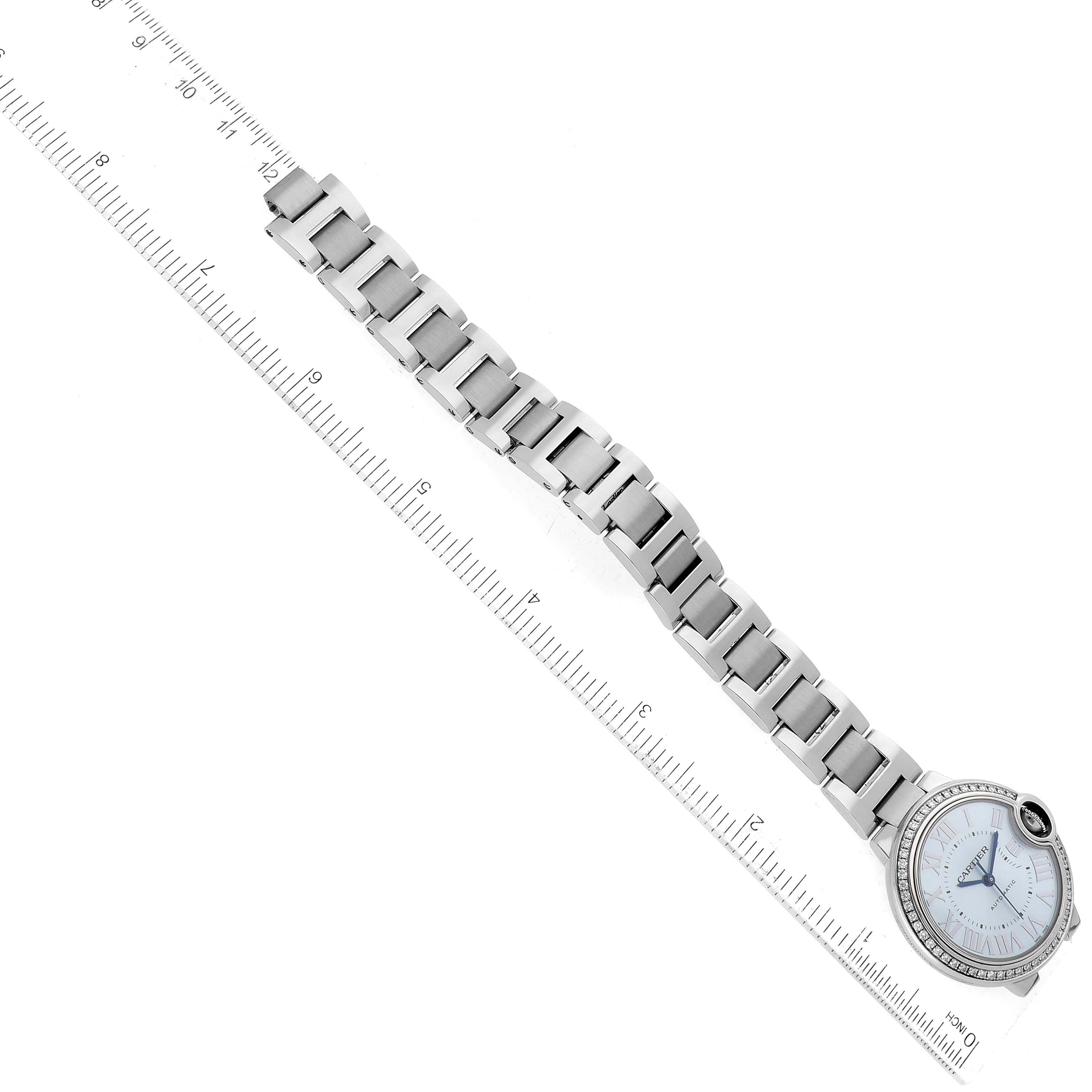 The image shows the Ballon Bleu by Cartier watch laid flat with its bracelet aligned with a ruler for measurement.