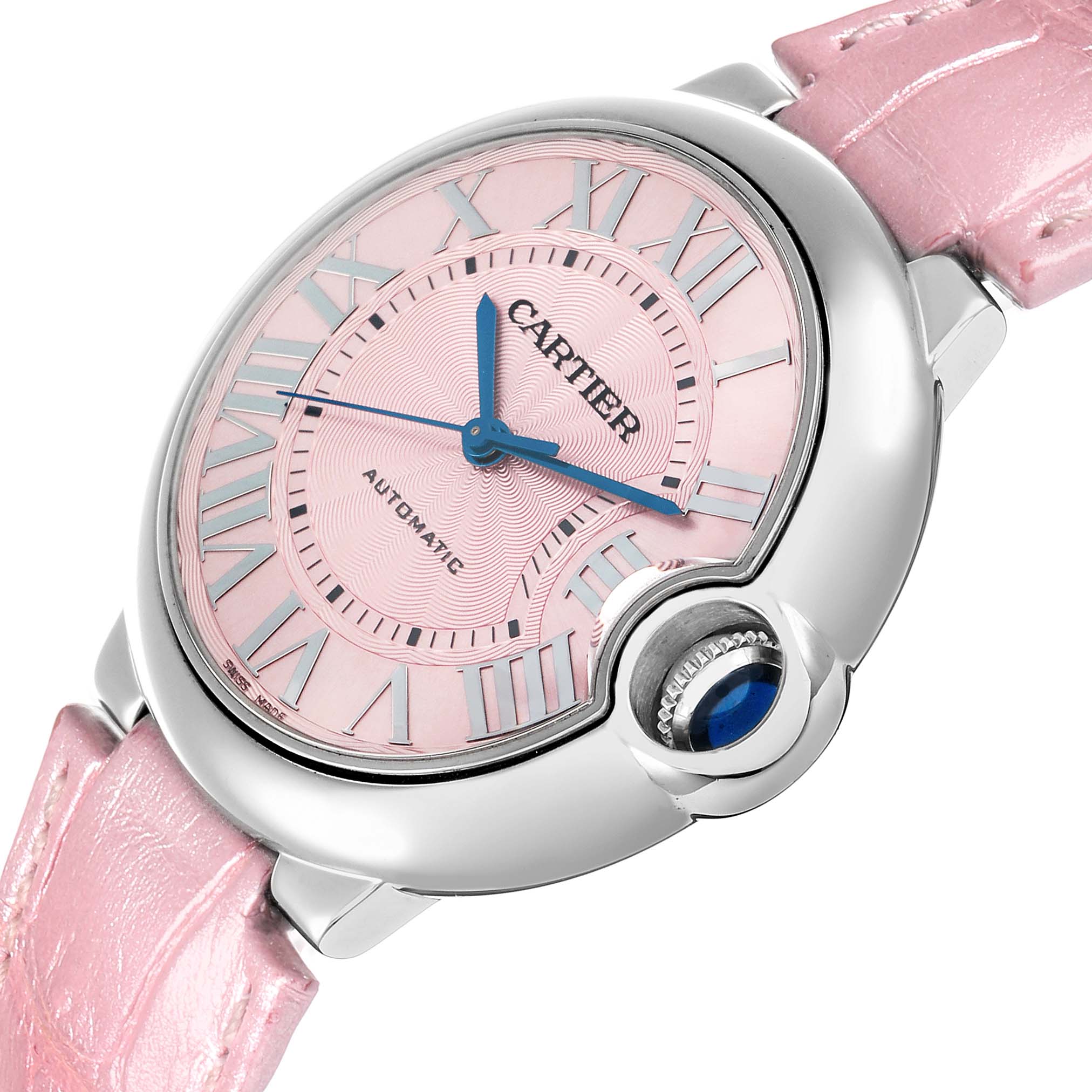 The Ballon Bleu by Cartier is shown at an angled view, displaying its pink dial, Roman numerals, and distinctive crown with a blue cabochon.