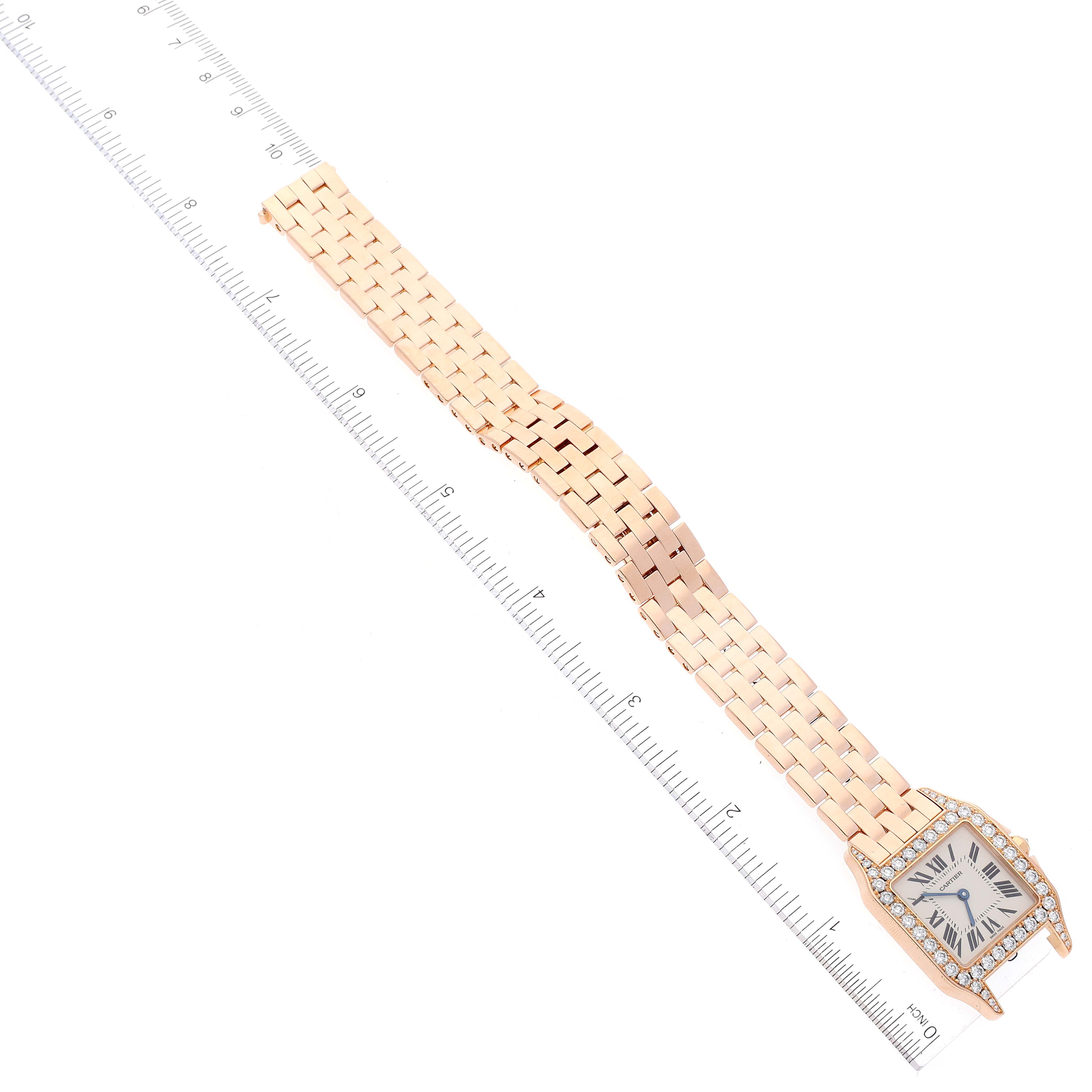 The image shows a Cartier Santos Demoiselle WF9007Z8 Women's Rose Gold Silver Dial WF9007Z8 Women's Rose Gold Silver Dial watch laid flat with a ruler beside it, displaying the watch face and full bracelet.