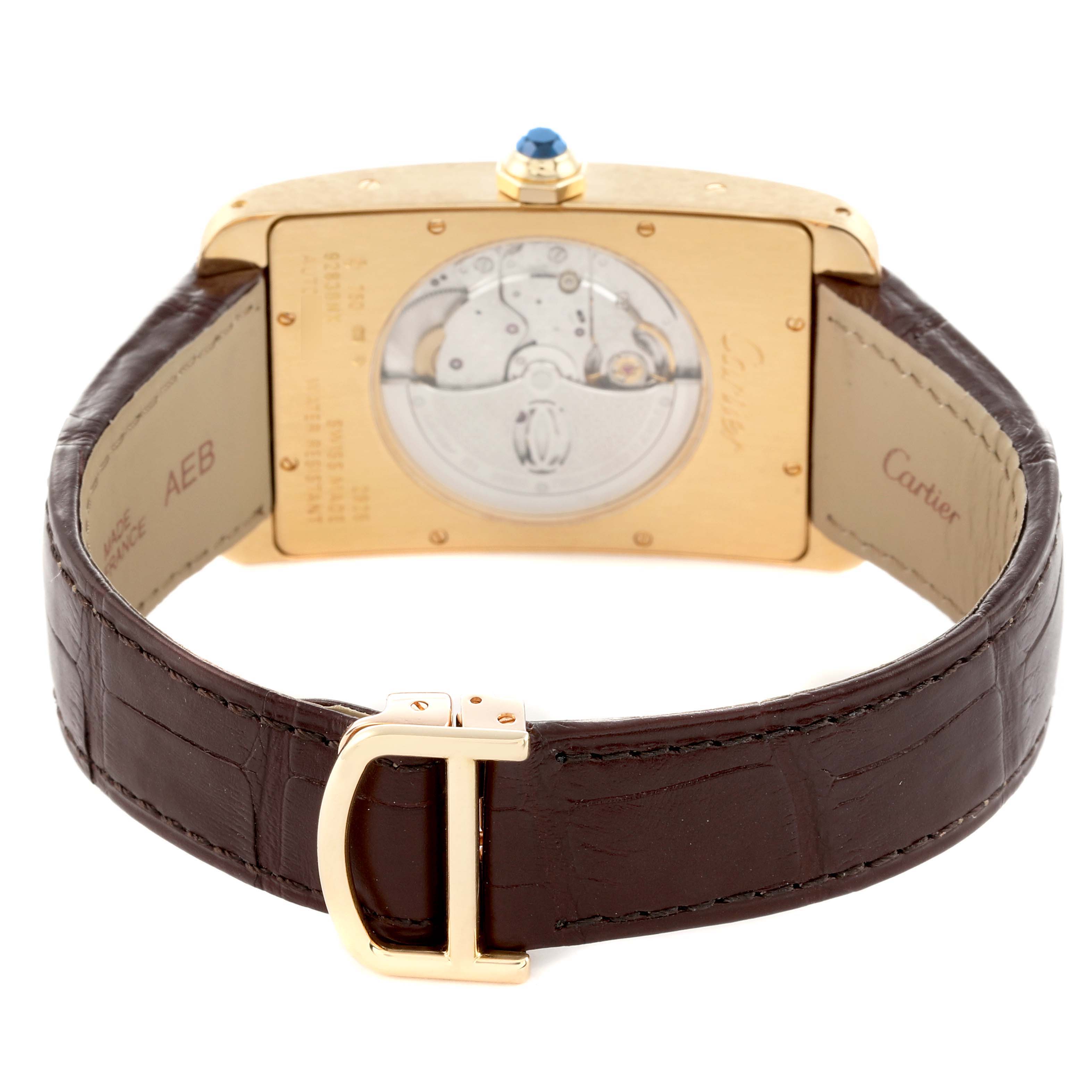The Cartier Tank Americaine W2609756 Men
s Yellow Gold Silver Dial watch is shown from the back, displaying the movement and leather strap with a gold buckle.