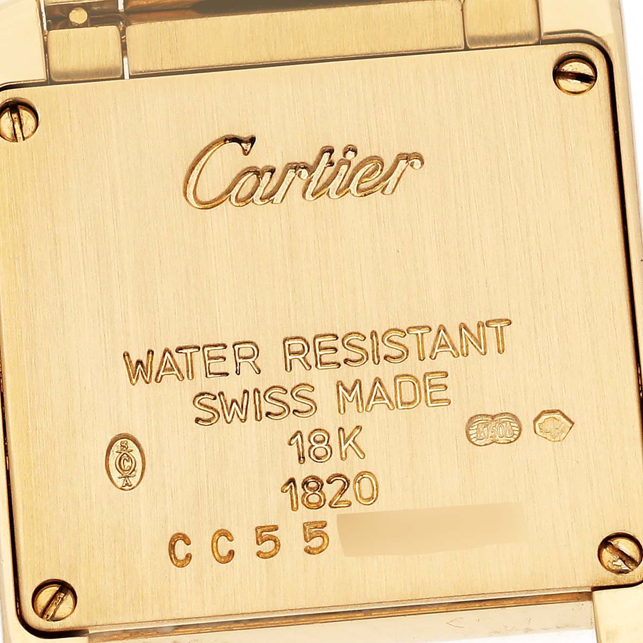 The image shows the case back of a Cartier Tank Française watch, revealing inscriptions and markings in gold.