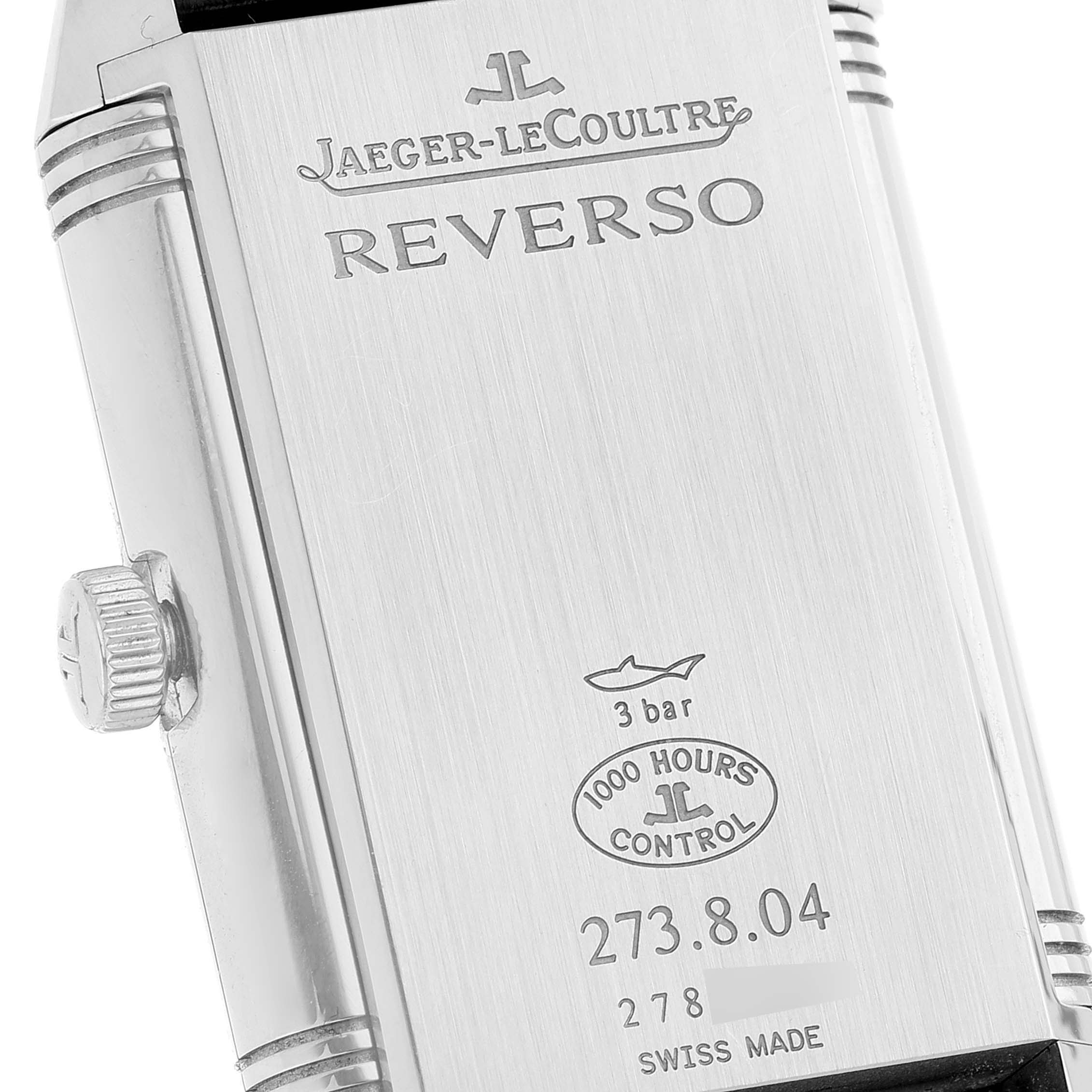 The image shows the backside of a Jaeger-LeCoultre Reverso watch, highlighting the engravings and serial numbers.