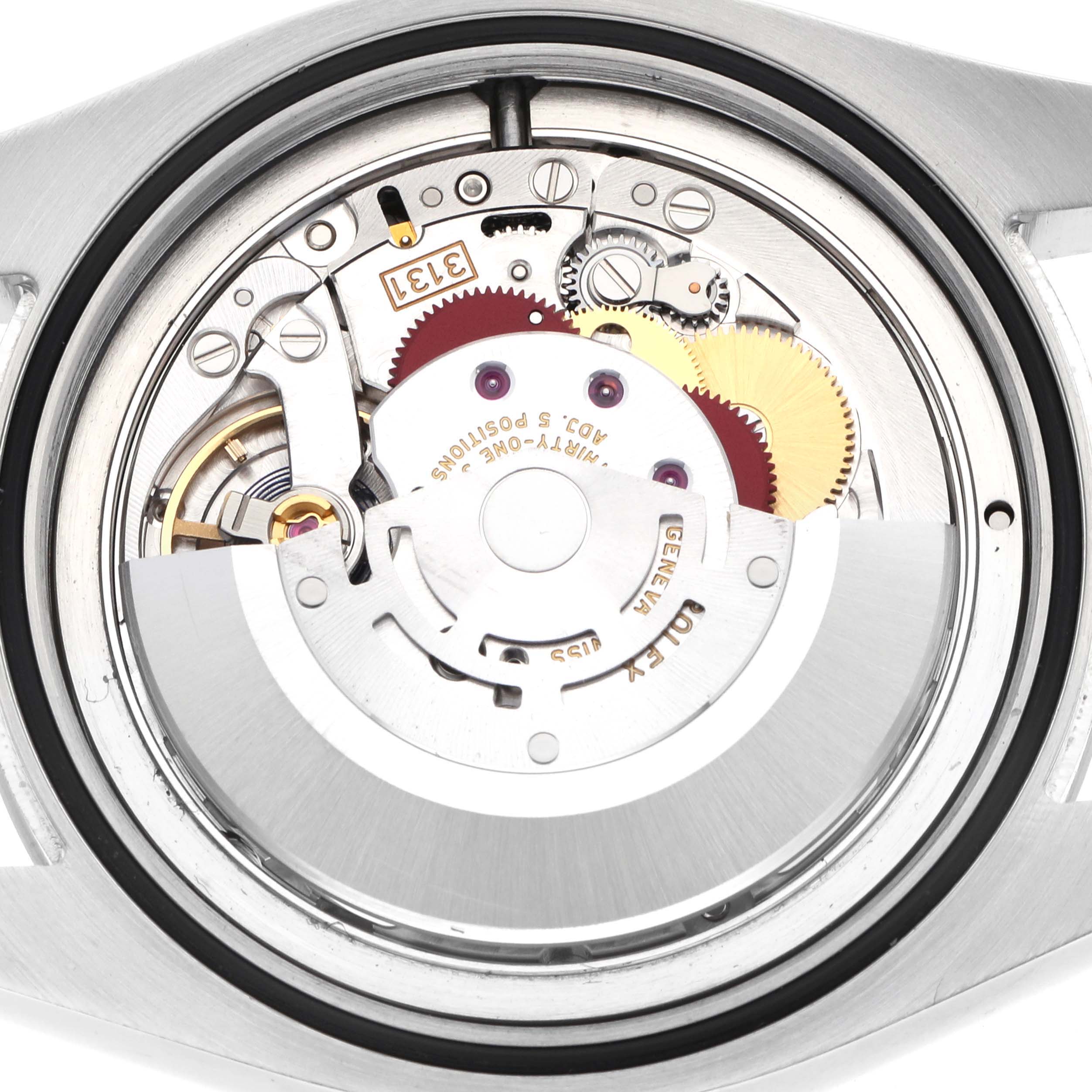 The image shows the movement of a Rolex Air-King 116900 Men
s Stainless Steel Black Dial watch from a top-down angle, highlighting gears and mechanical components.