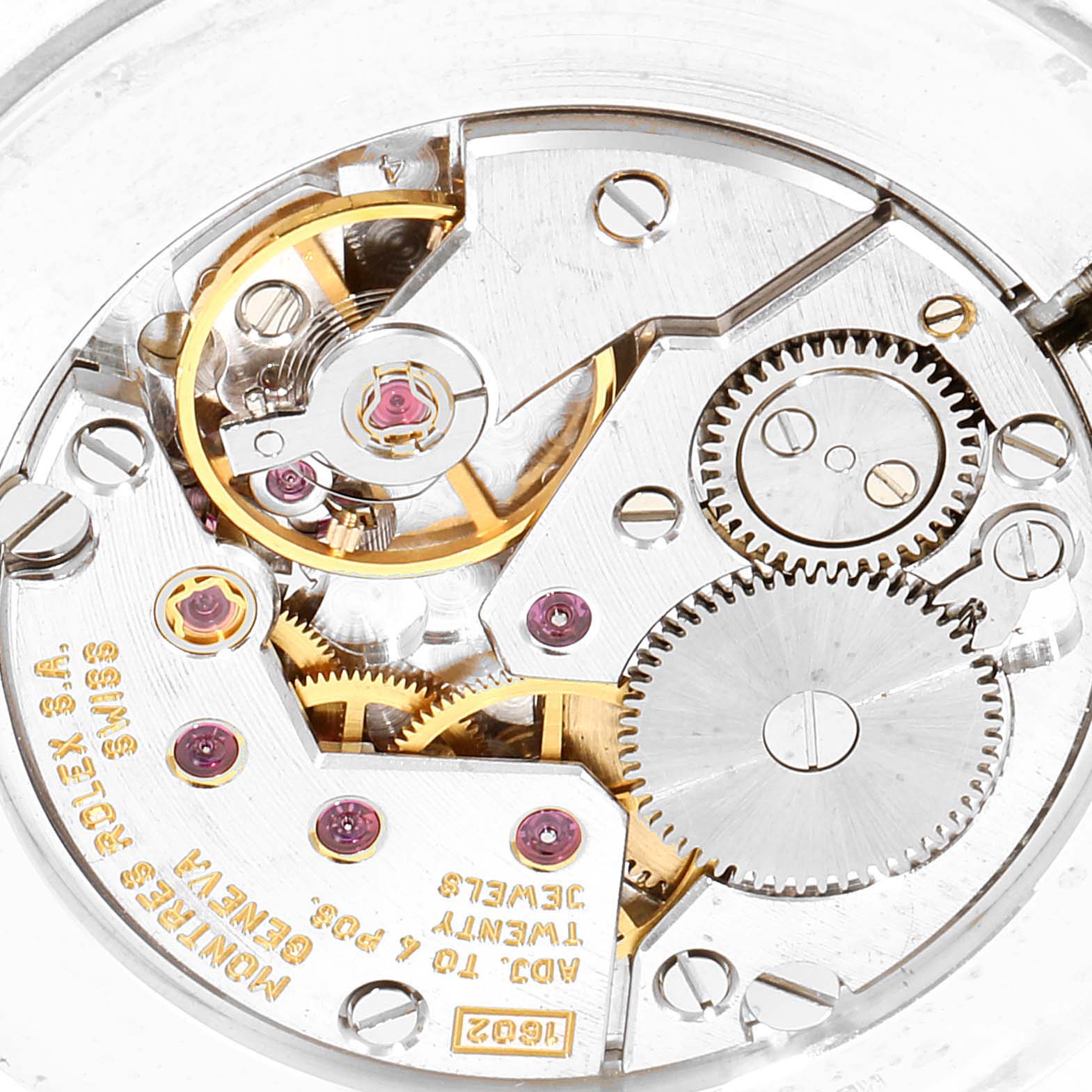 This image shows a close-up of the internal mechanism of a Rolex Cellini 5112 Men's Yellow Gold Beige Dial 5112 Men's Yellow Gold Beige Dial watch, highlighting gears, jewels, and inscriptions.