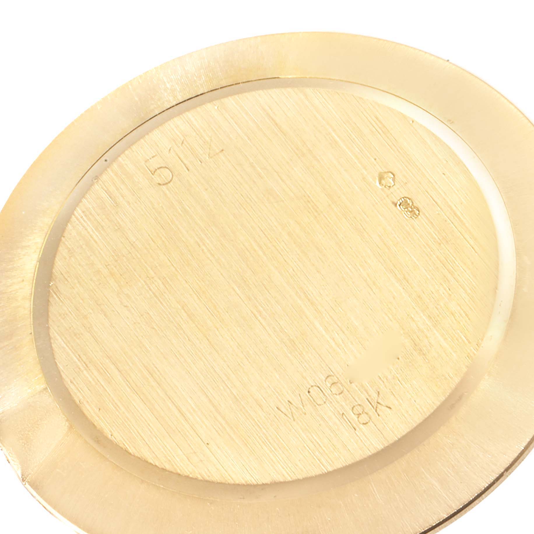 This image shows the back case of a Rolex Cellini 5112 Men's Yellow Gold Beige Dial 5112 Men's Yellow Gold Beige Dial watch, highlighting its engravings and 18K gold material.