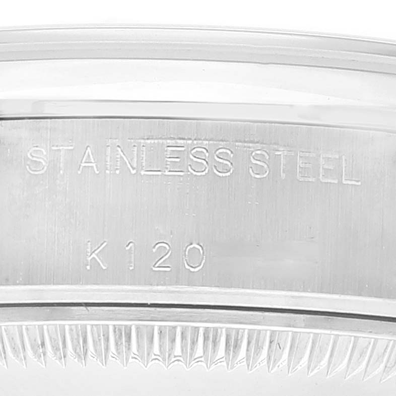 This image shows an engraved "STAINLESS STEEL" marking and part of the bezel of a Rolex Date 79160 Women's Stainless Steel Silver Dial 79160 Women's Stainless Steel Silver Dial model watch.