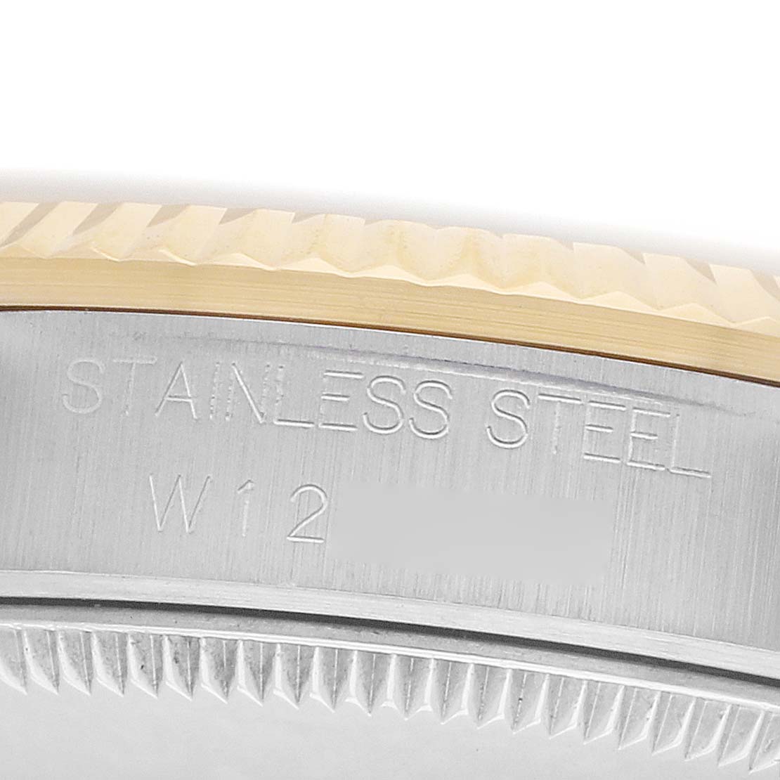 The image shows a close-up of the side of a Rolex Mid-Size 68273 Women
s Steel and Gold (two tone) White Dial model, focusing on the engraved "STAINLESS STEEL" text.