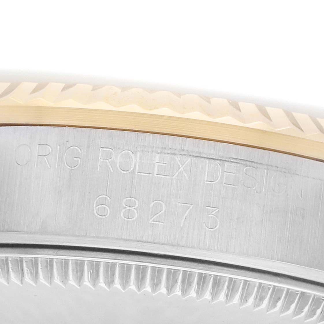 The image shows a close-up of the case side of a Rolex Mid-Size 68273 Women
s Steel and Gold (two tone) White Dial model, with engraved details and part of the fluted bezel.