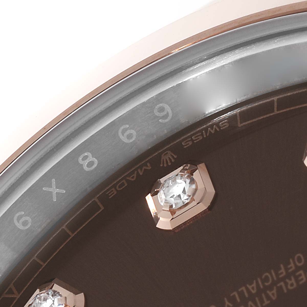 This close-up image of a Rolex Datejust 41 126301 Men's Steel and Gold (two tone) Brown Dial 126301 Men's Steel and Gold (two tone) Brown Dial watch showcases the bezel and part of the dial with diamond hour markers.