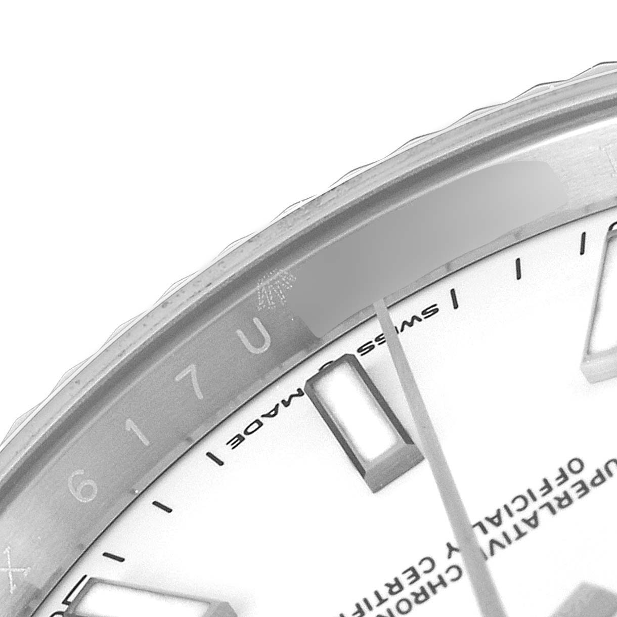 This close-up image of the Rolex Datejust 41 126334 Men
s Stainless Steel White Dial 126334 Men
s Stainless Steel White Dial watch shows the edge of the bezel, part of the dial, and some hour markers.