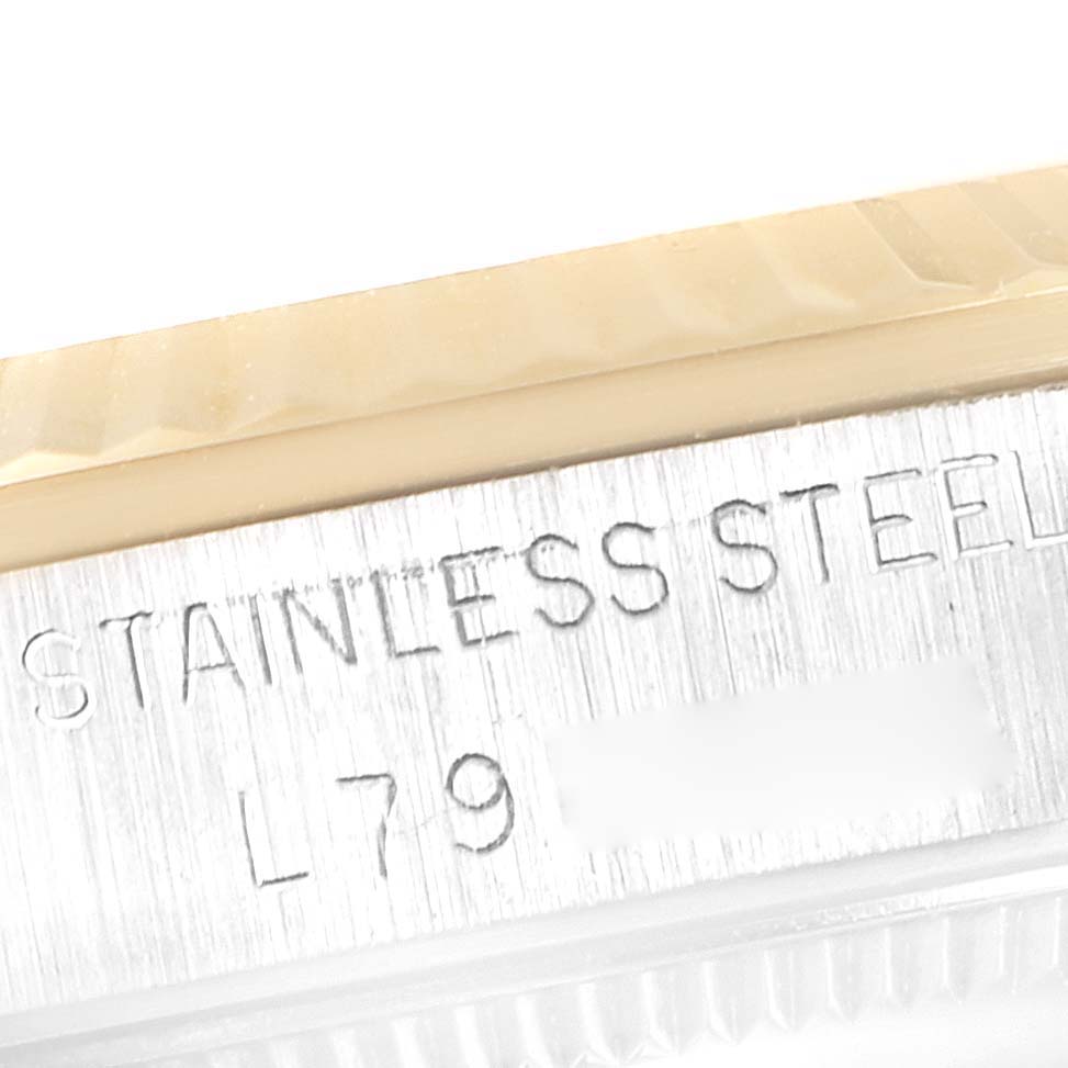 This image shows a close-up of the case side of a Rolex Mid-Size 68273 Women's Steel and Gold (two tone) Champagne Dial 68273 Women's Steel and Gold (two tone) Champagne Dial watch, displaying the "STAINLESS STEEL" engraving.